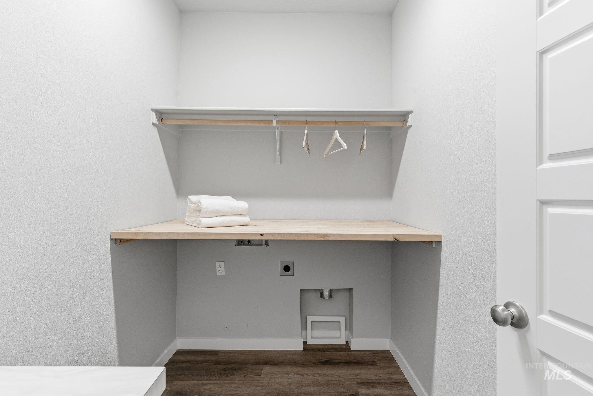 Laundry room featuring electric dryer hookup and dark wood-type flooring