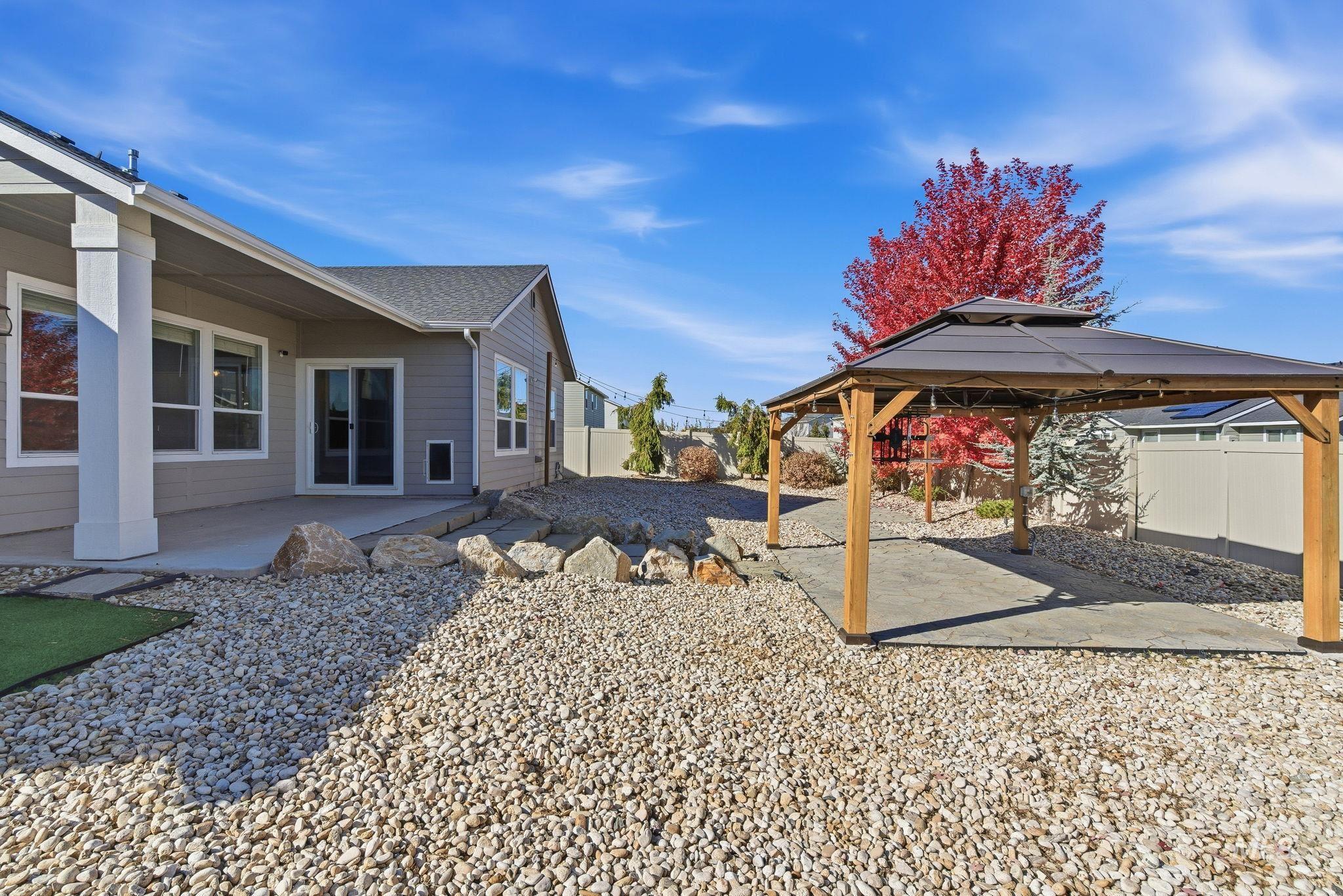 Fenced backyard featuring a patio area and a gazebo