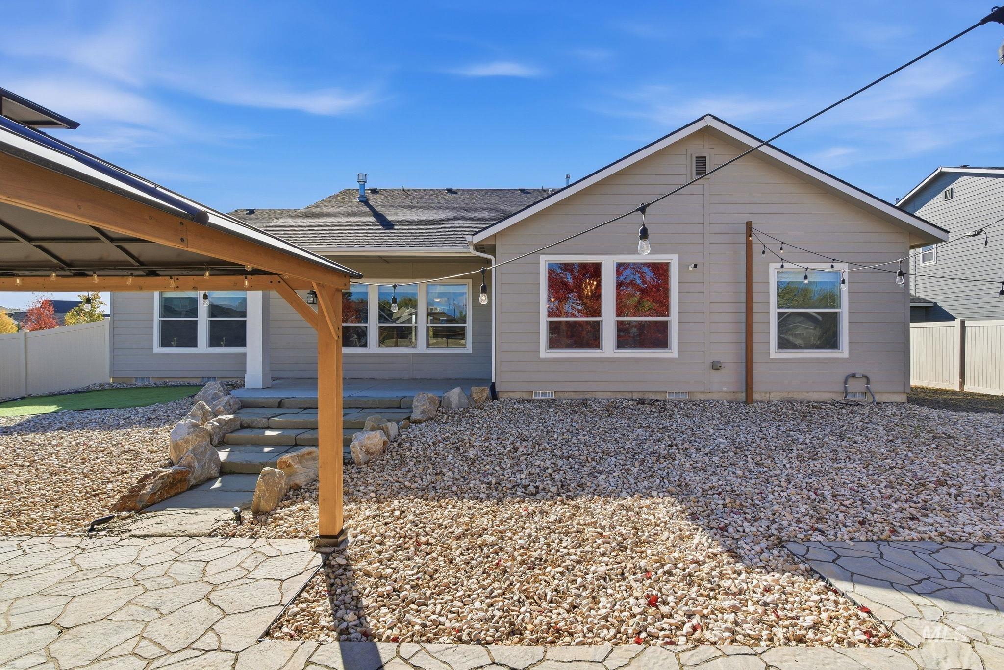 Back of house with a patio and a shingled roof