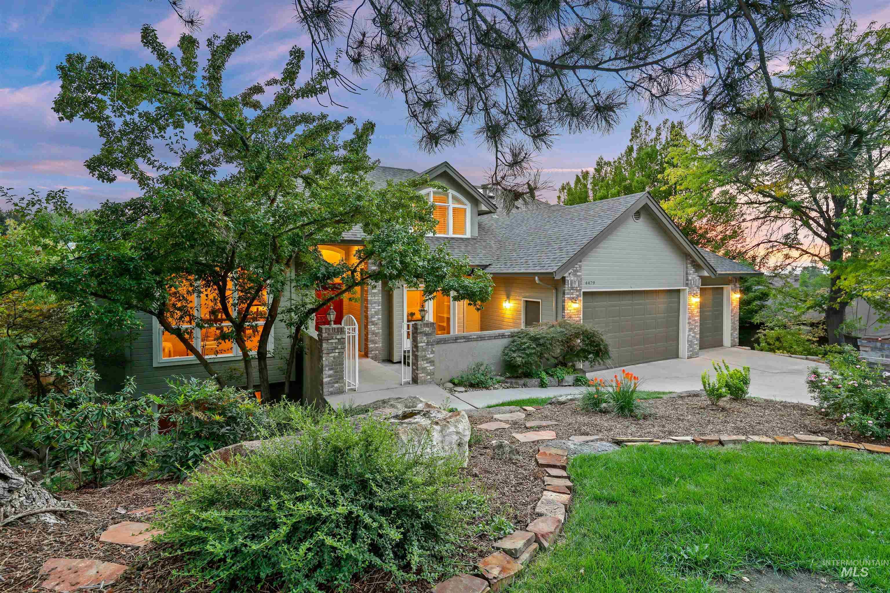 View of front of home with stone siding, a garage, concrete driveway, a porch, and roof with shingles