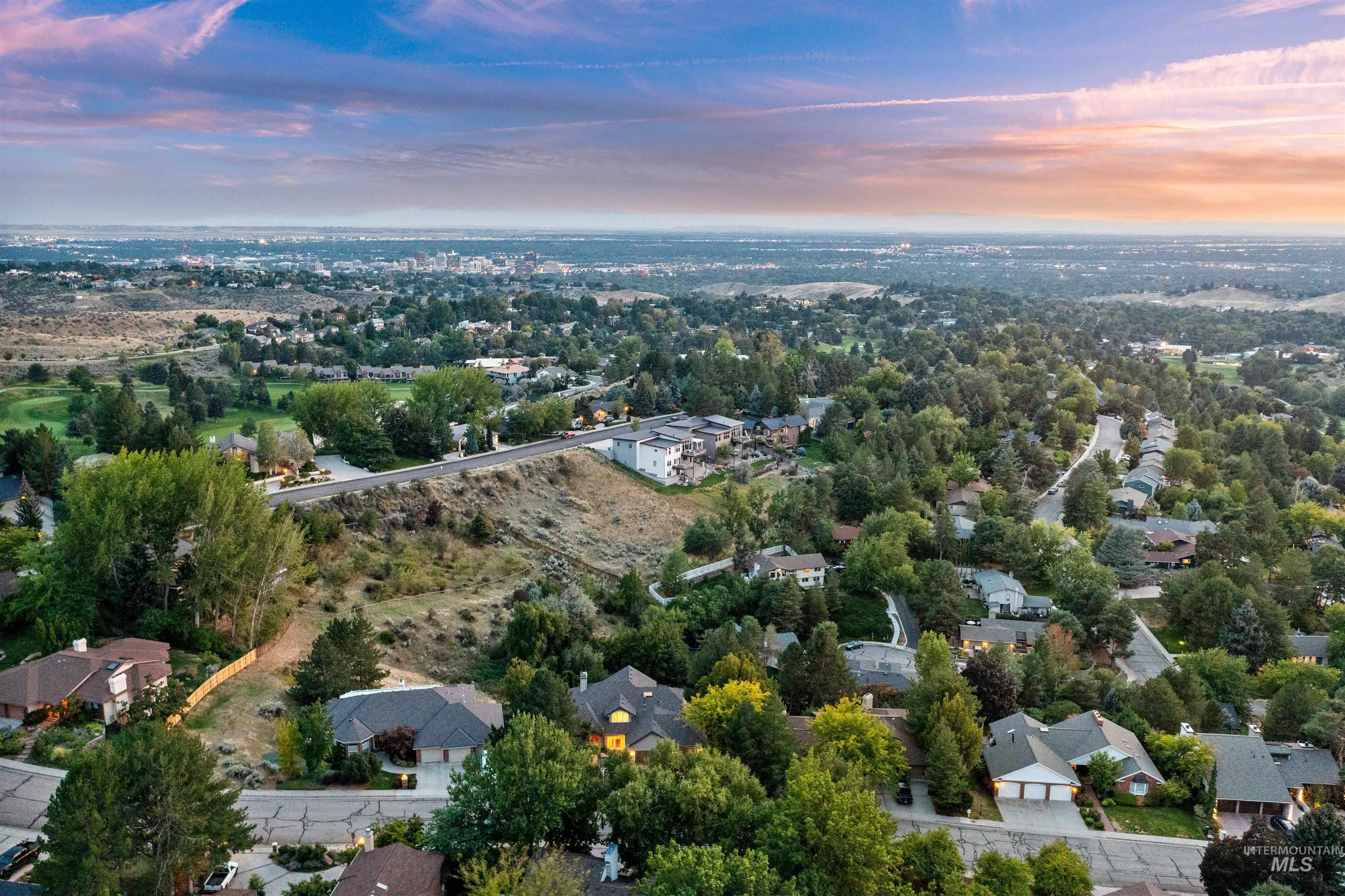 Aerial view at dusk of a residential view and view of scattered trees