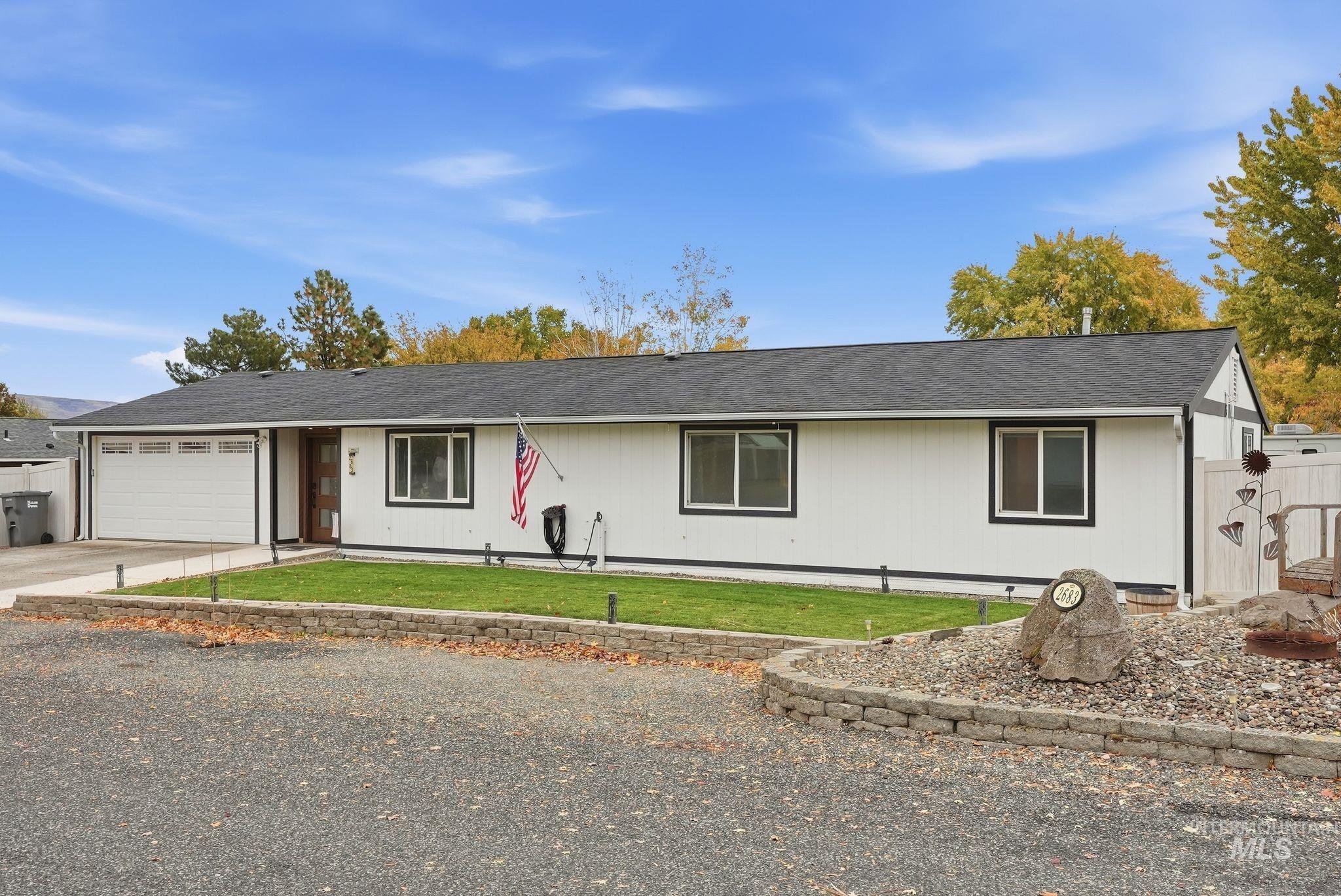 Ranch-style home with concrete driveway, a shingled roof, and a garage