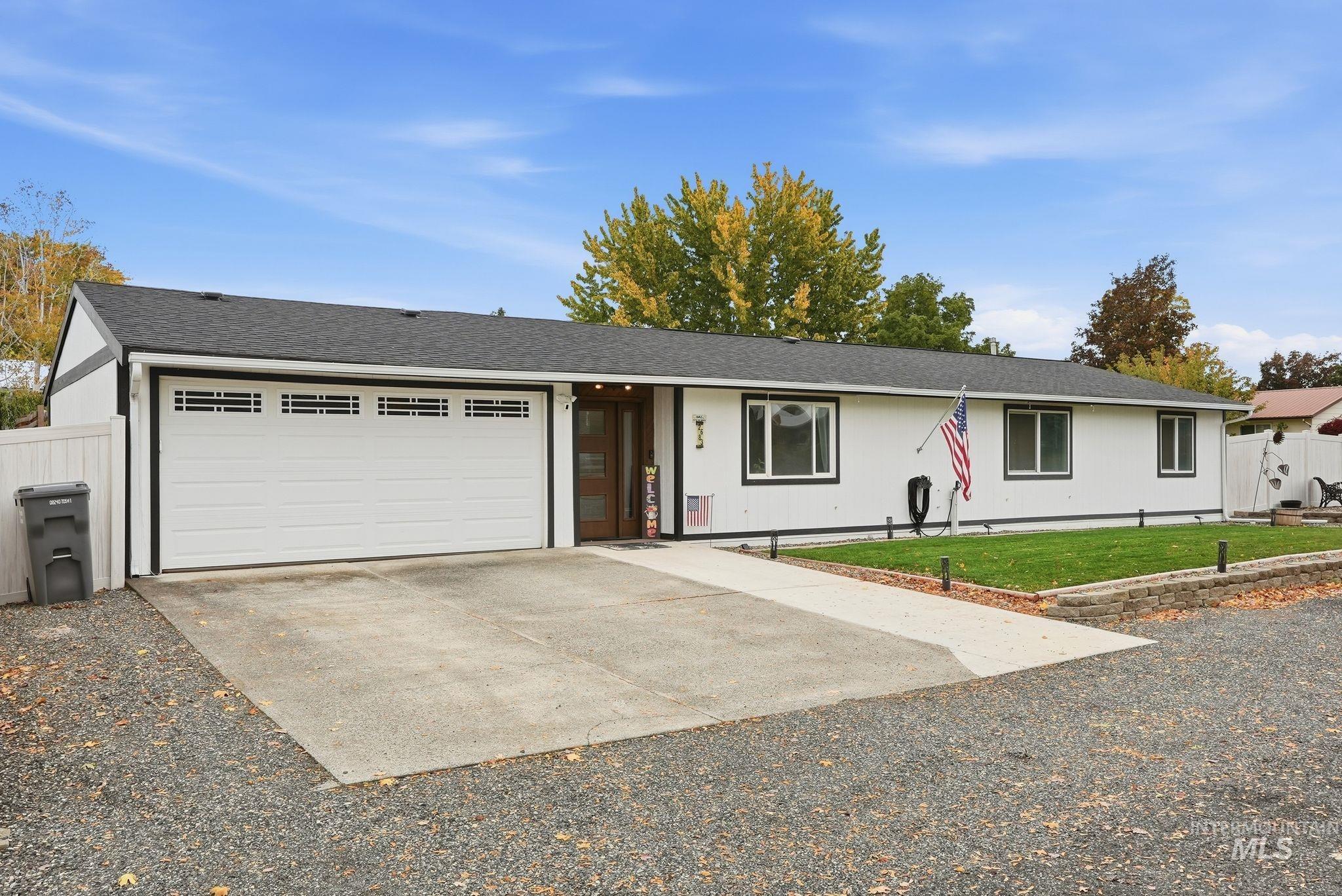 Single story home with concrete driveway, a shingled roof, and a garage