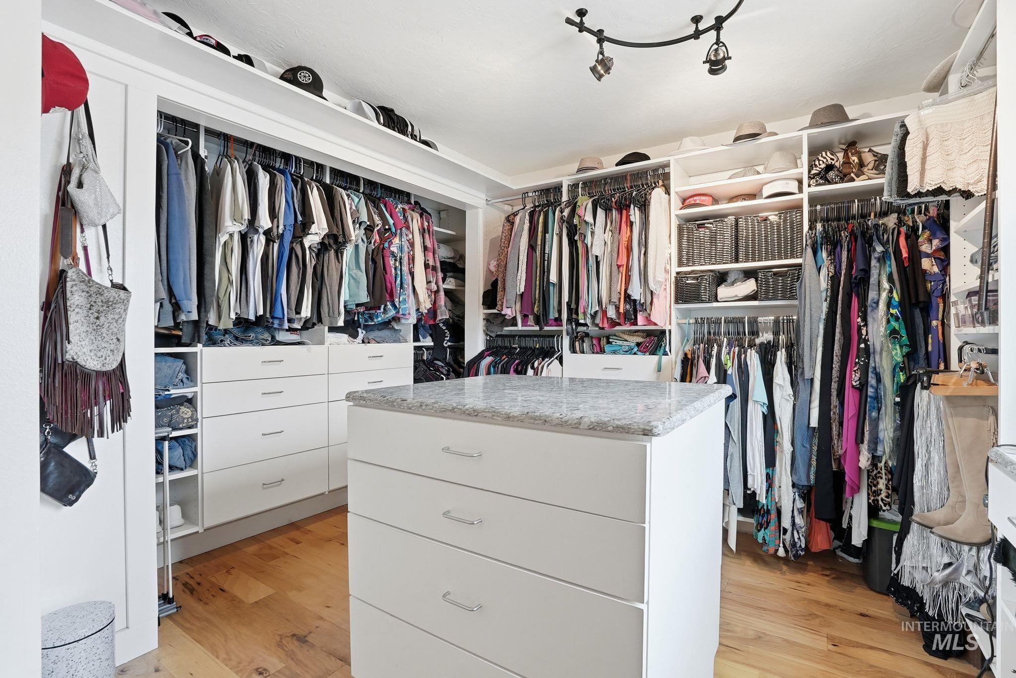 Walk in closet with light wood-style floors