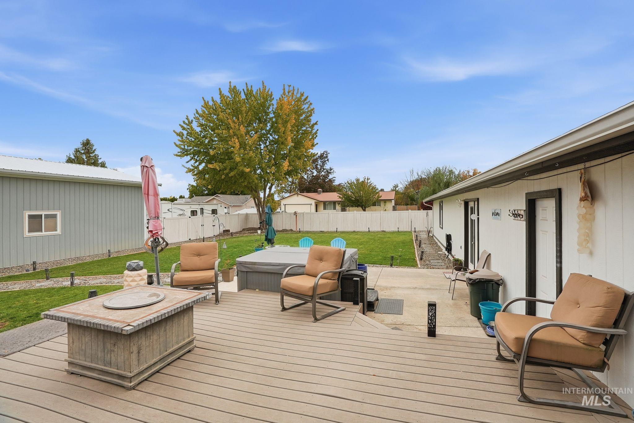 Wooden deck with a fenced backyard and a patio
