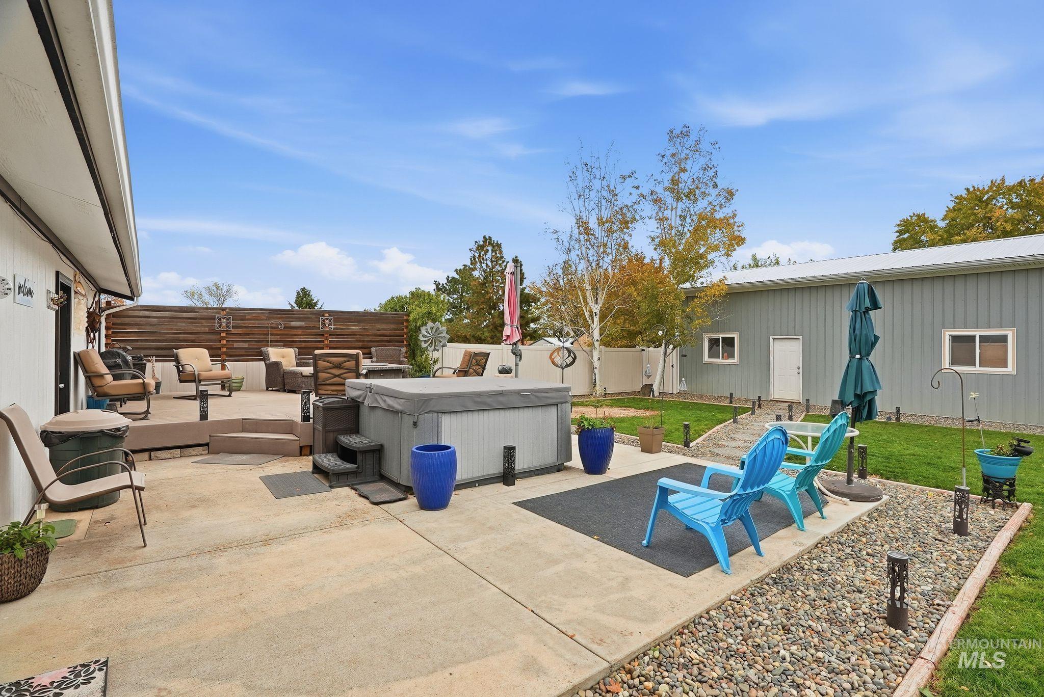 Fenced backyard featuring a patio area and a hot tub