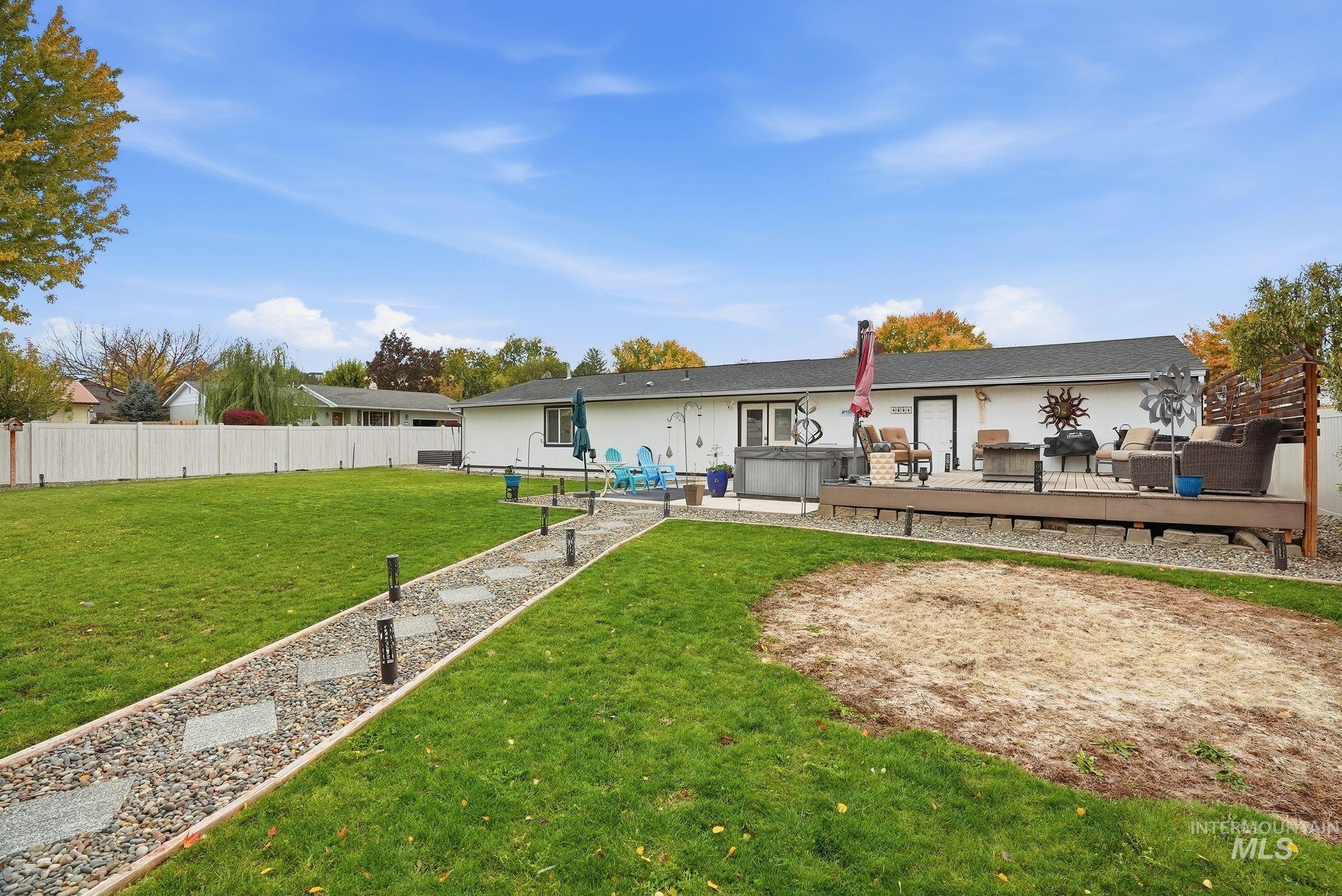 Rear view of property featuring a deck, a hot tub, and a patio