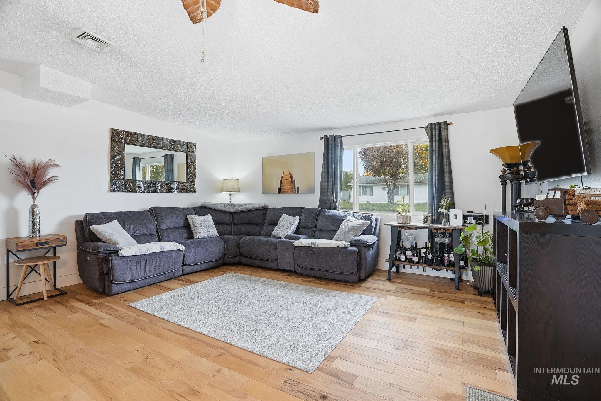 Living area with light wood finished floors and a ceiling fan