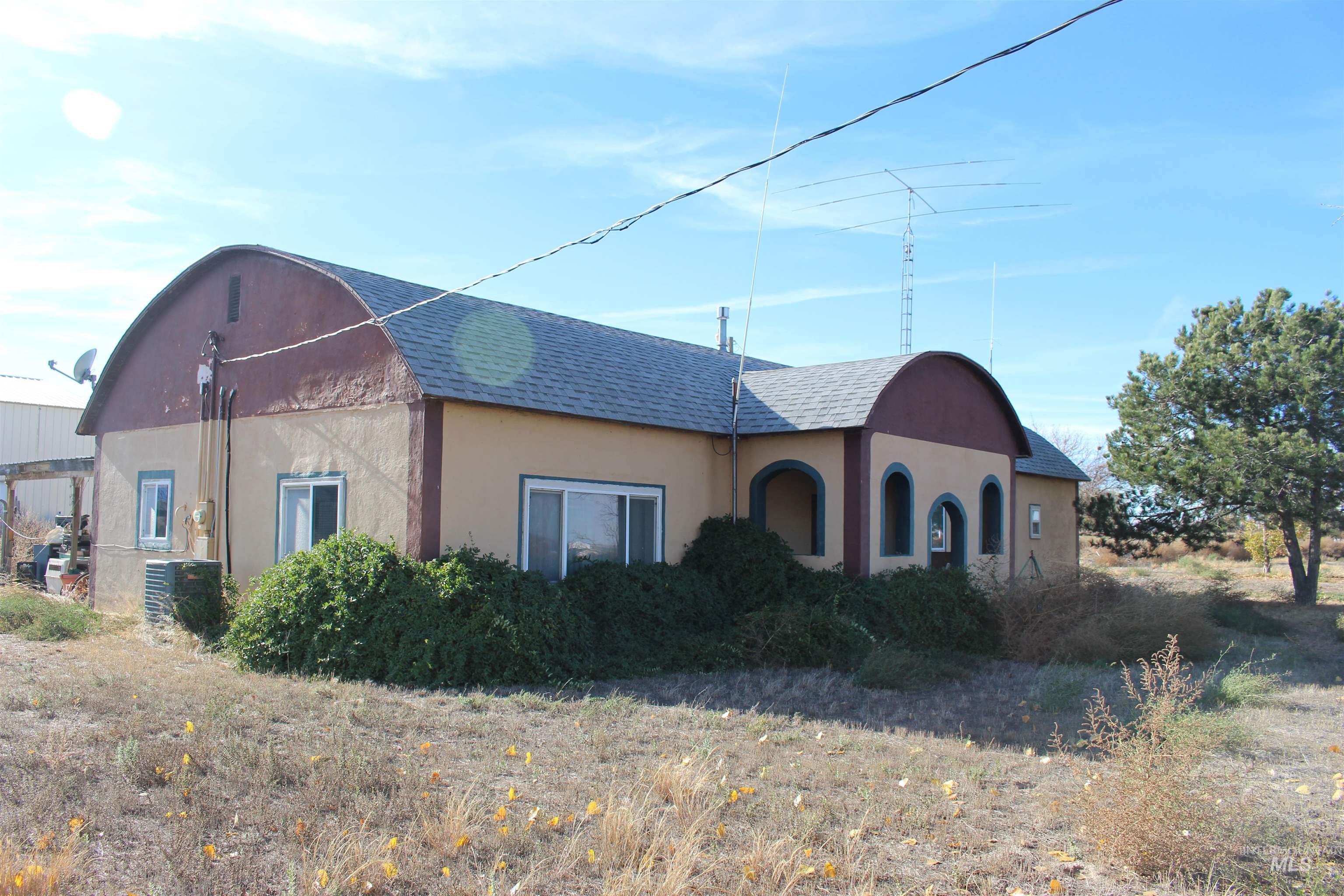 View of front facade featuring a shingled roof and stucco siding