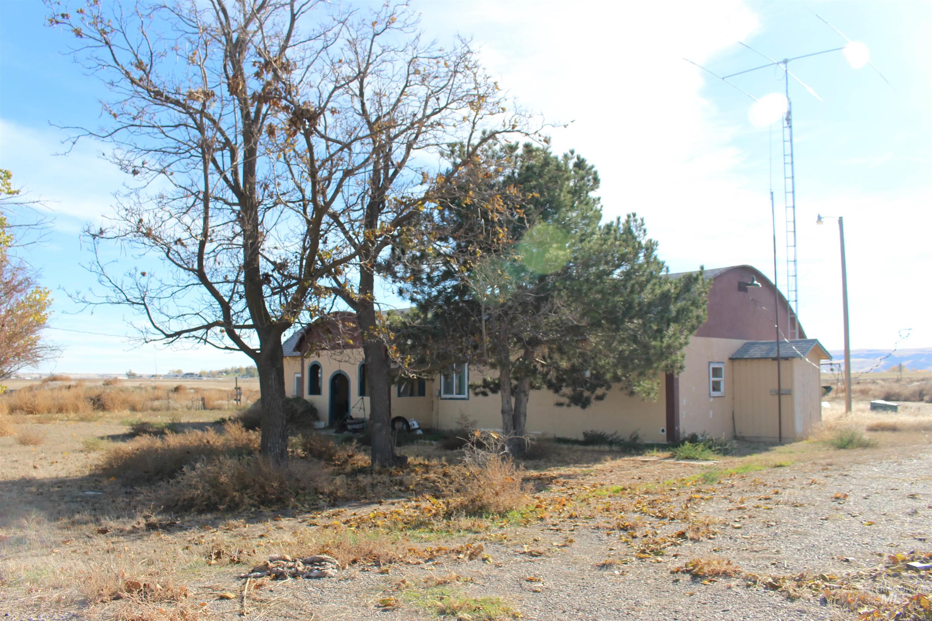 View of front facade with stucco siding, an outdoor structure, and a barn