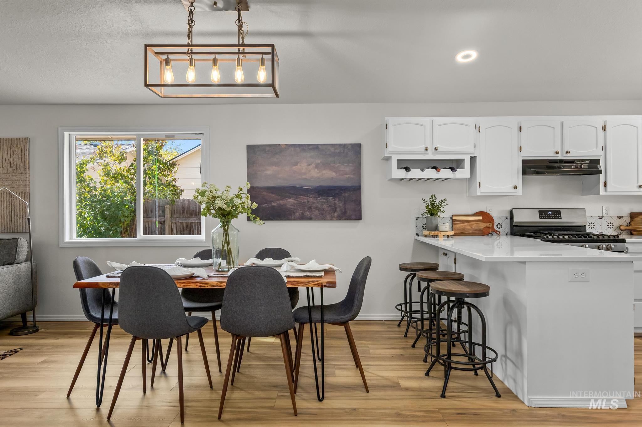 Dining area with light wood-style floors and recessed lighting