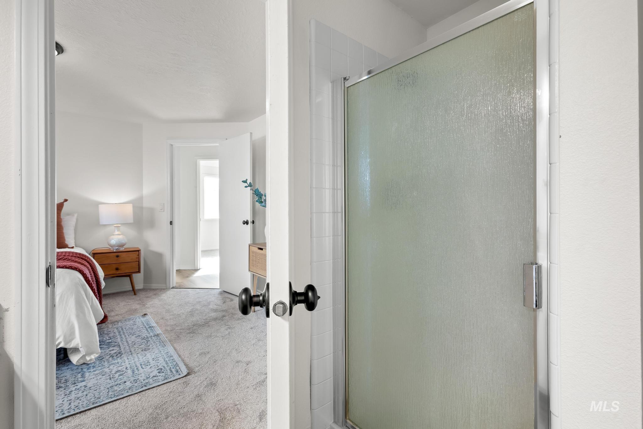 Full bathroom featuring carpet floors, a shower stall, and connected bathroom