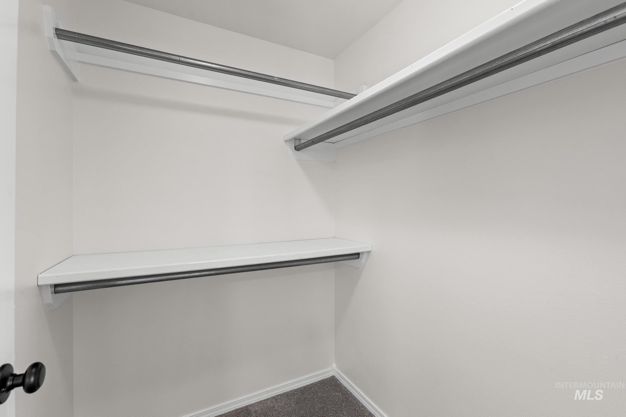 Walk in closet featuring dark carpet