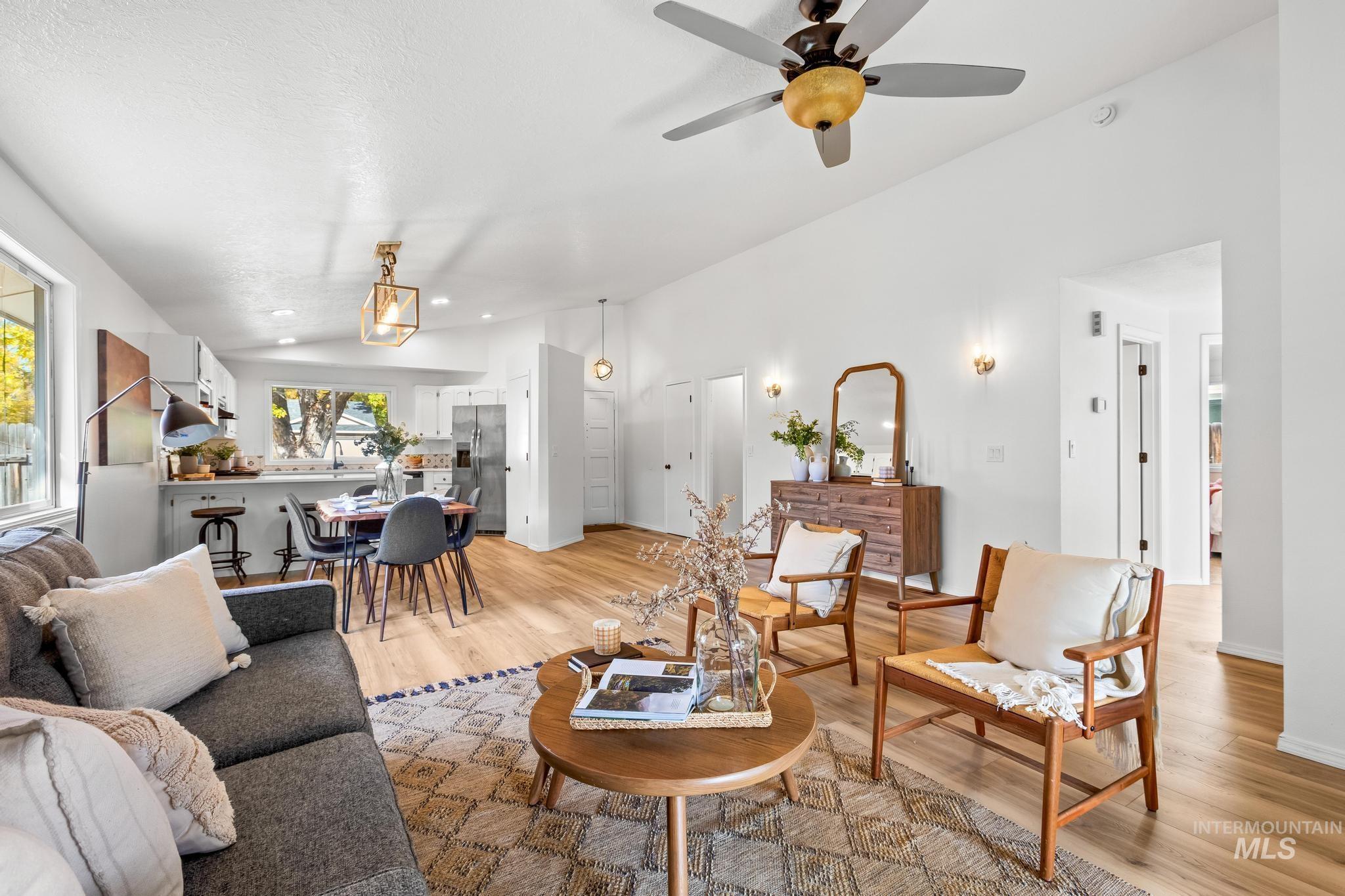 Living room featuring light wood-type flooring, vaulted ceiling, recessed lighting, and a ceiling fan