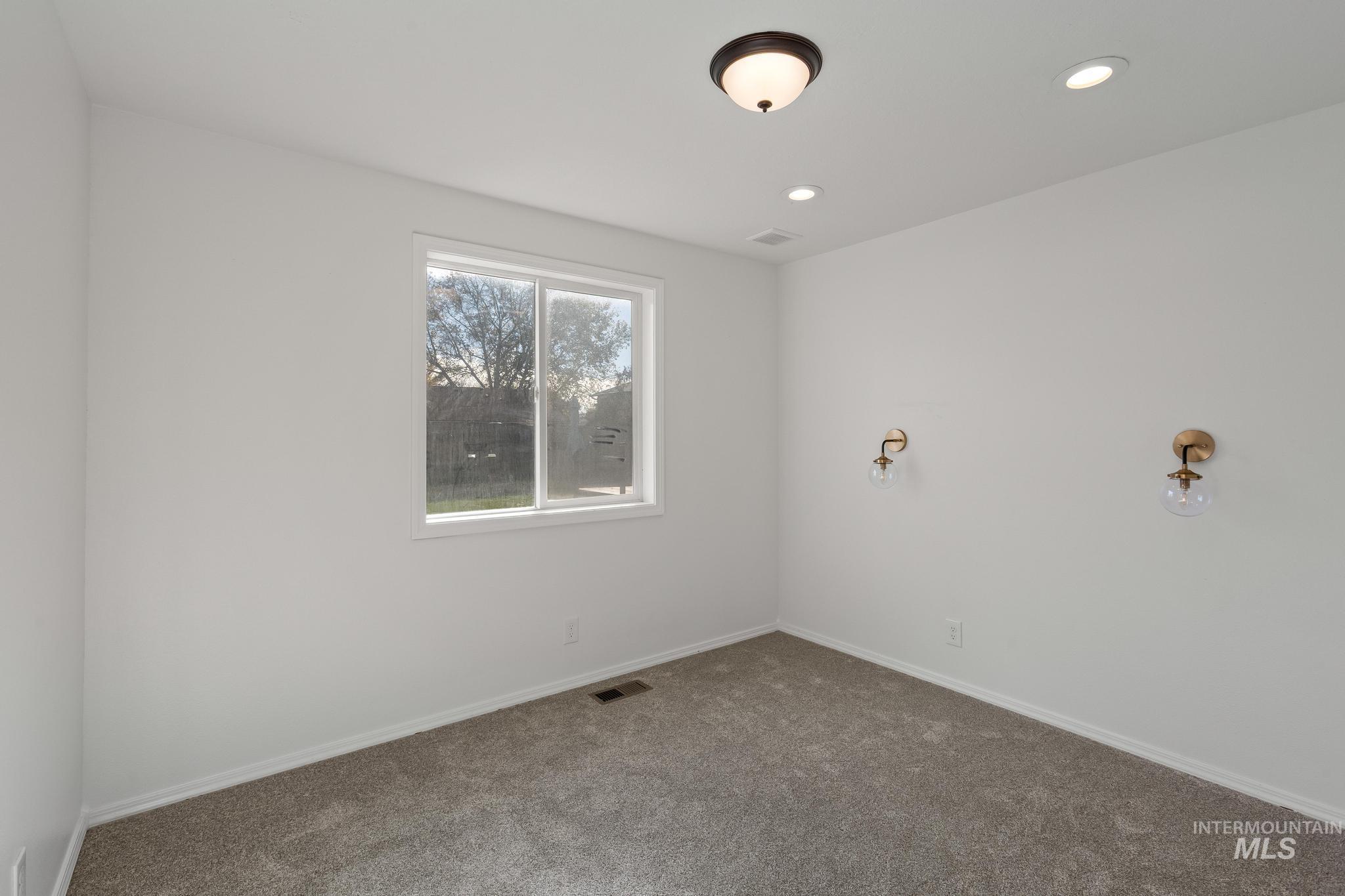 Carpeted empty room with baseboards and recessed lighting