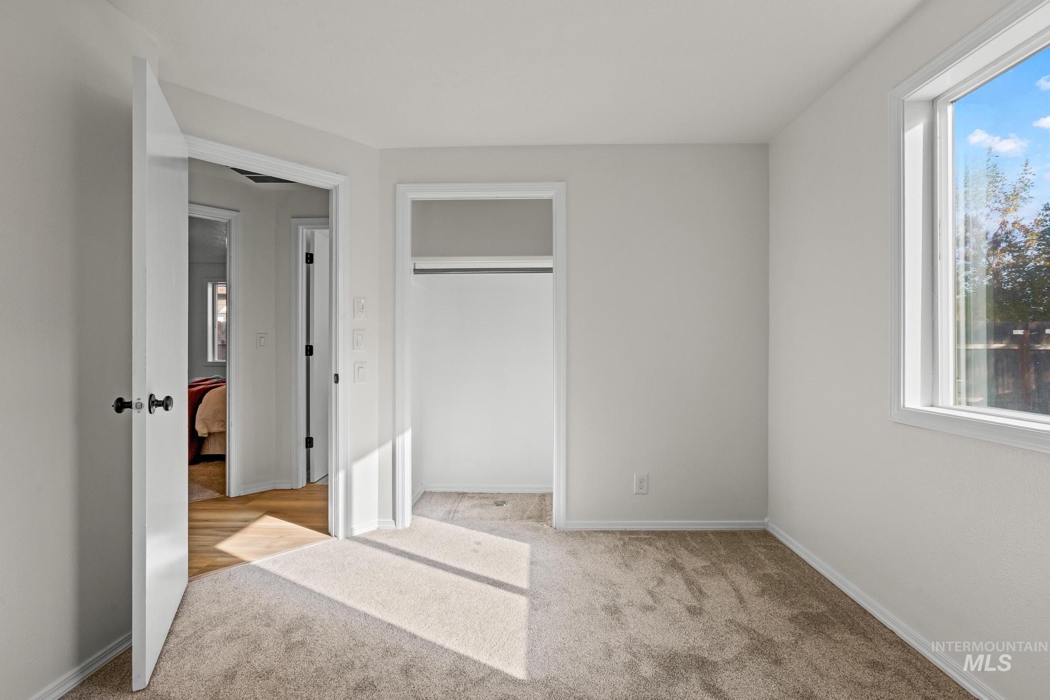 Unfurnished bedroom with carpet floors, a closet, and multiple windows