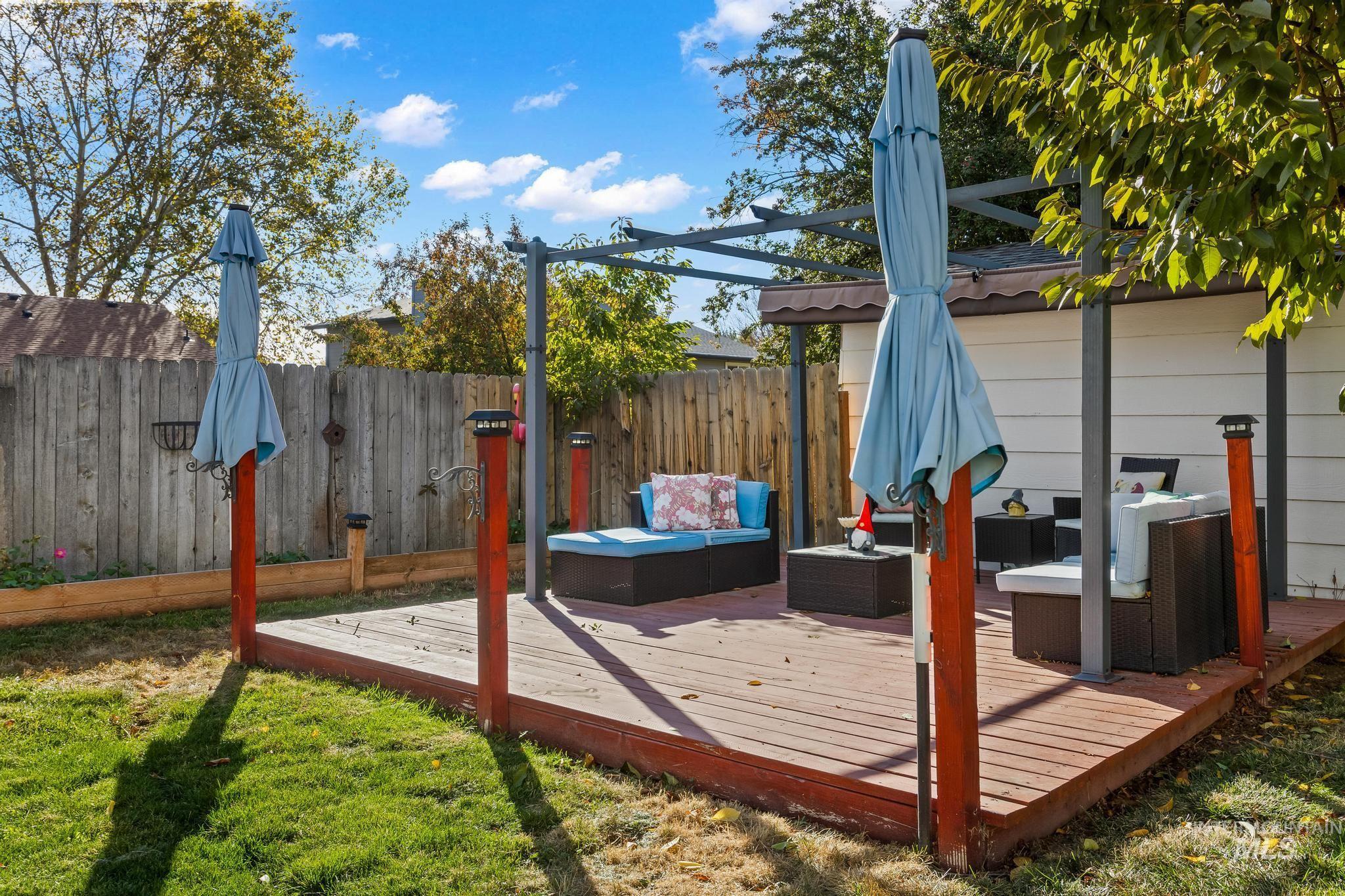 Wooden deck with an outdoor hangout area and a fenced backyard