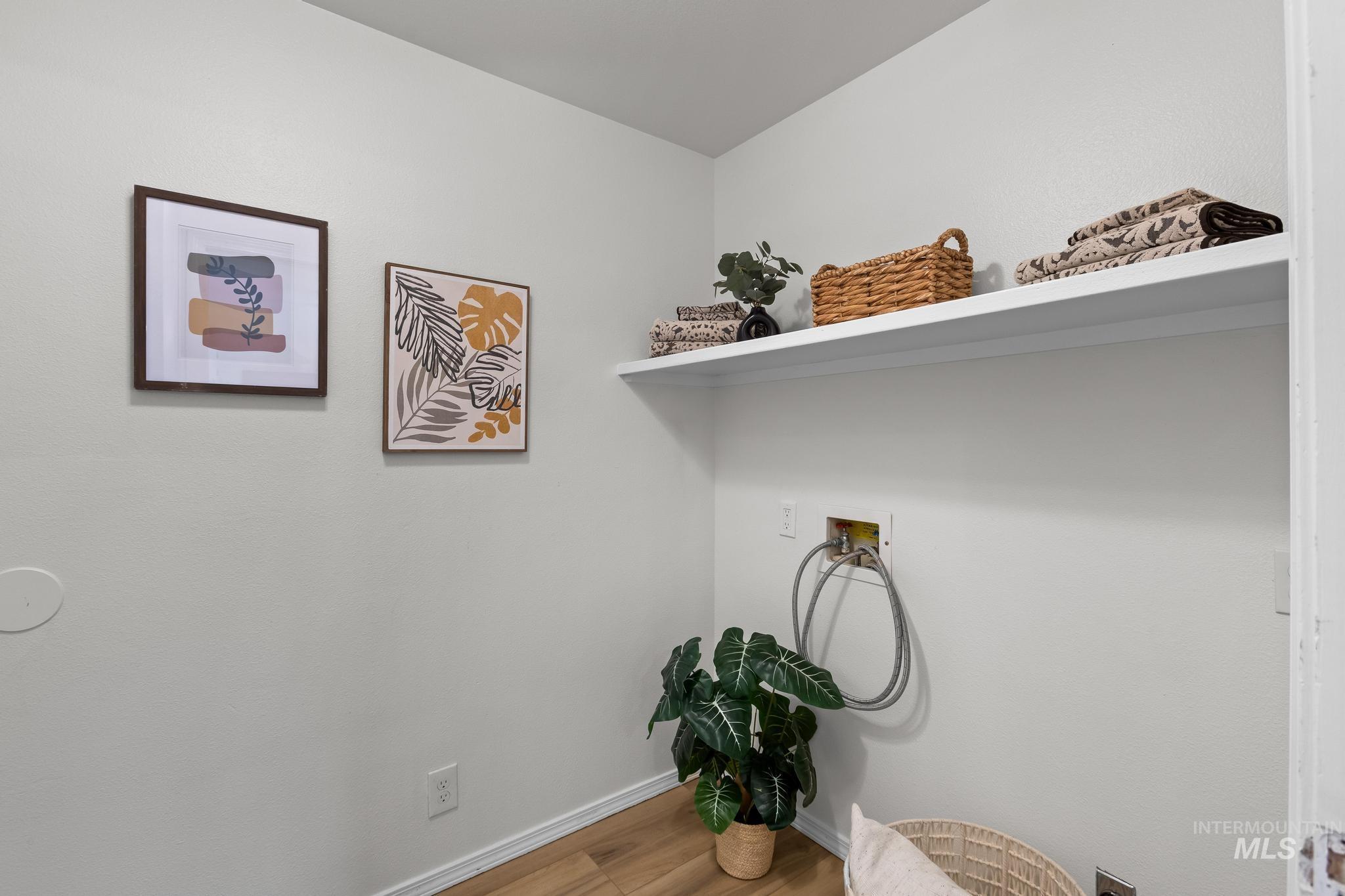 Laundry room featuring wood finished floors and washer hookup