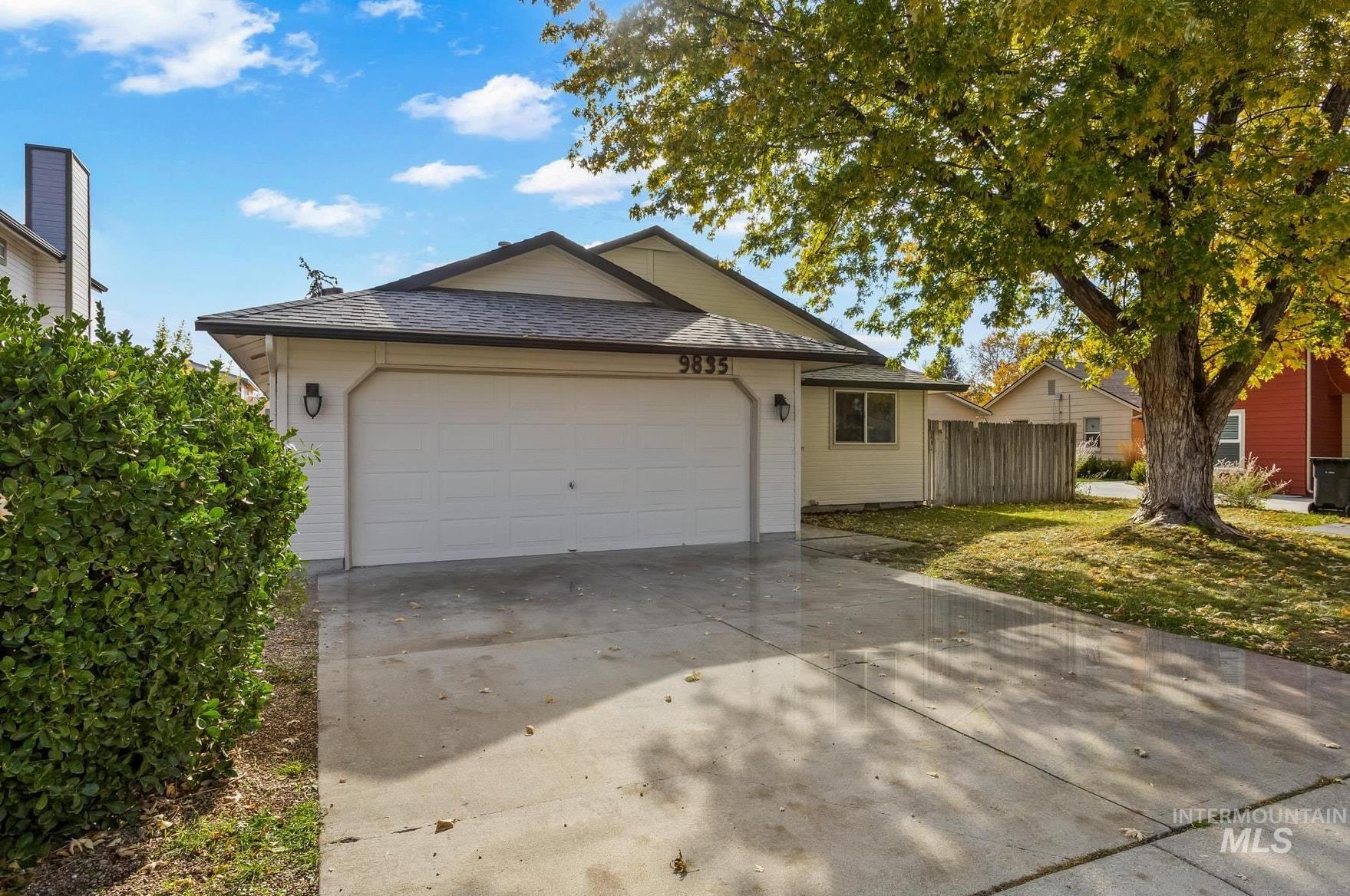 Ranch-style house featuring concrete driveway, an attached garage, and a shingled roof