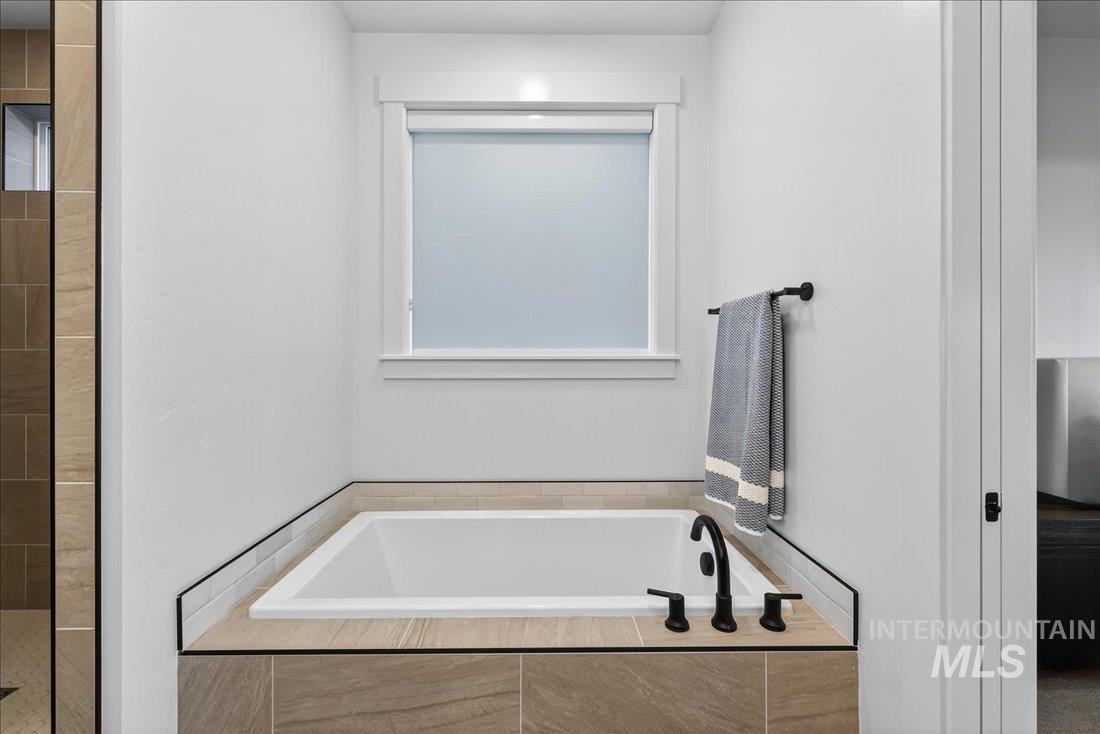 Bathroom featuring a garden tub and tiled shower
