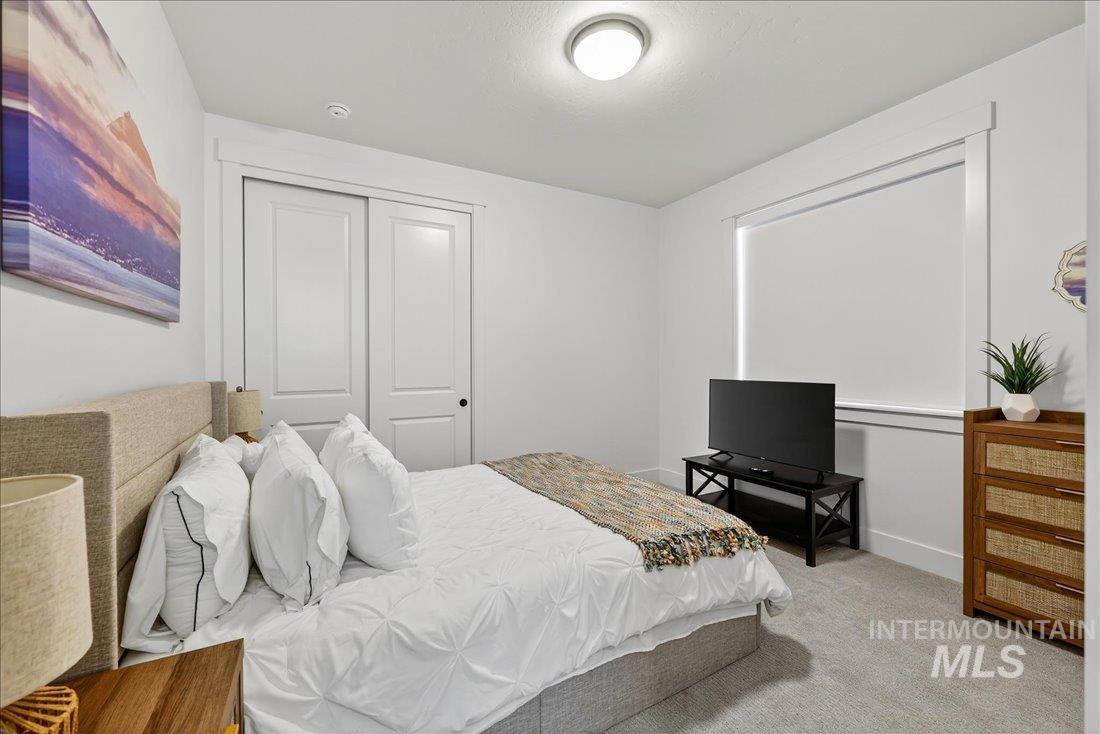 Bedroom featuring light colored carpet and a closet