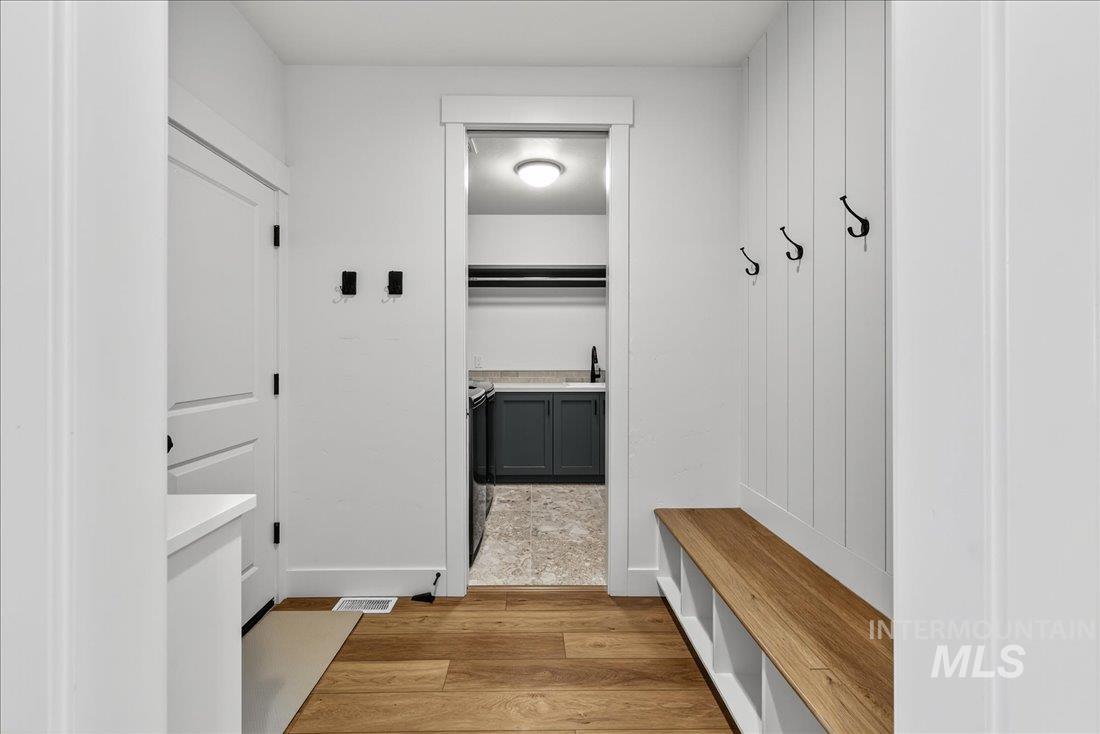 Mudroom with light wood-type flooring and a sink