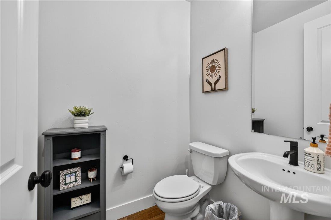 Half bath featuring toilet and wood finished floors