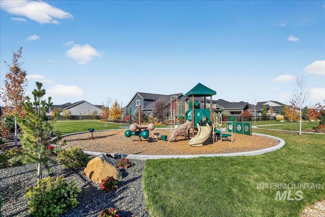 Community playground featuring a lawn and a residential view