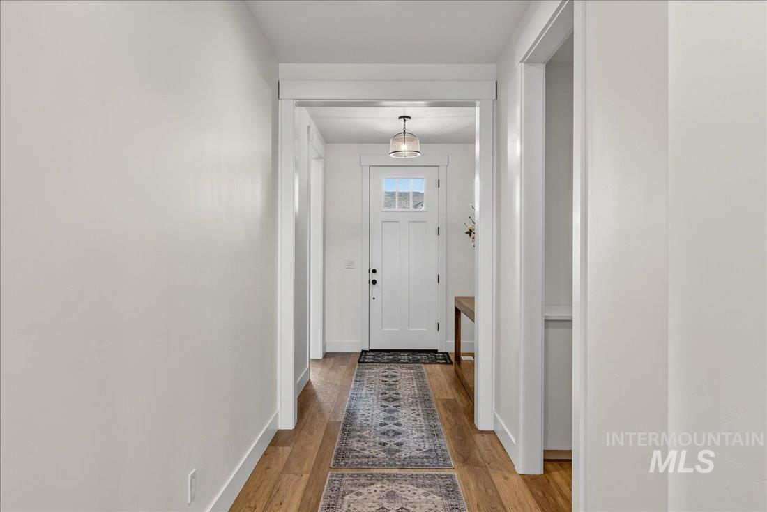 Entryway with wood finished floors and baseboards