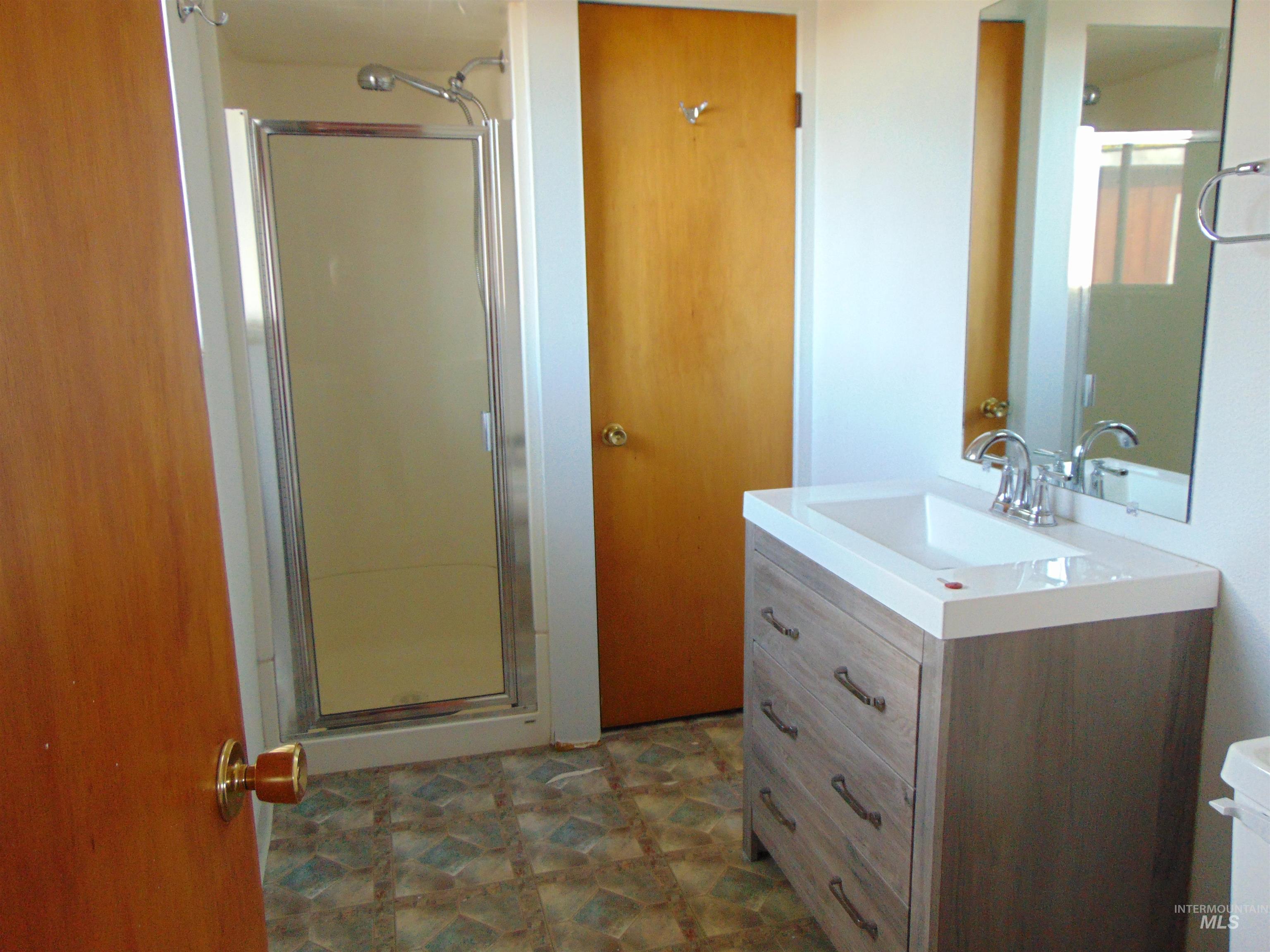 Full bathroom with vanity and a shower stall
