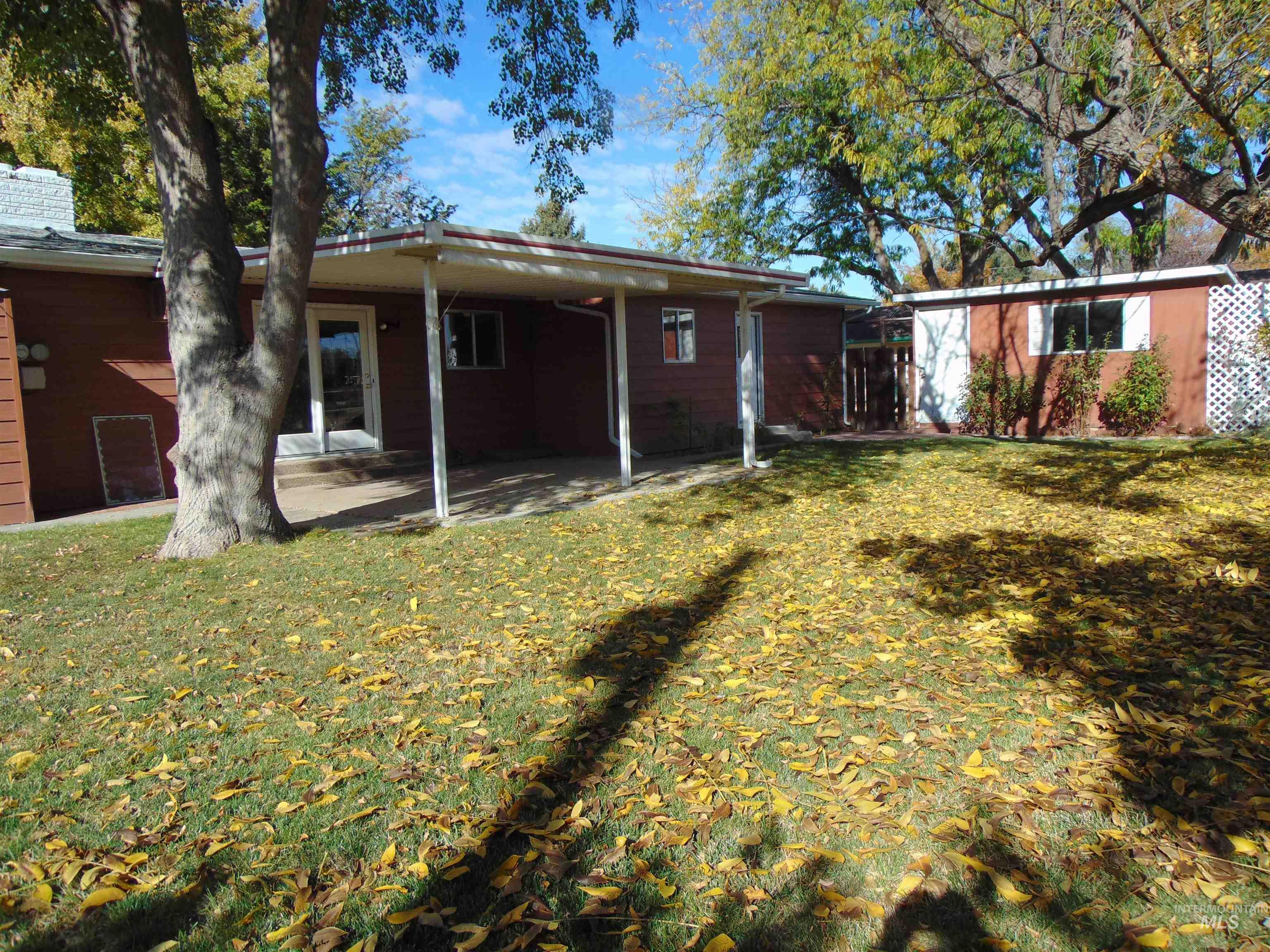 Back of property featuring a patio, a lawn, and a chimney