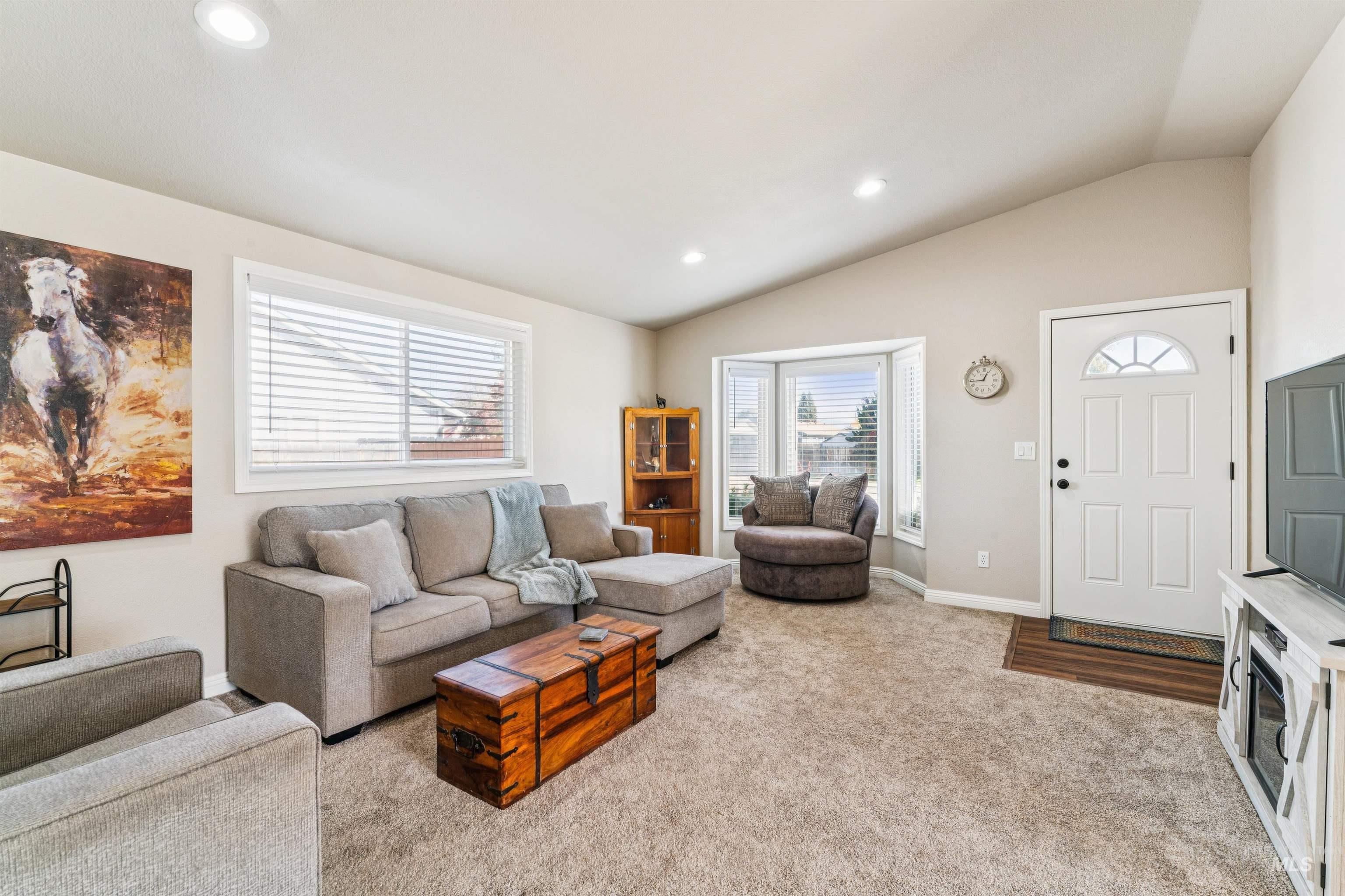 Living room with recessed lighting, vaulted ceiling, and light carpet