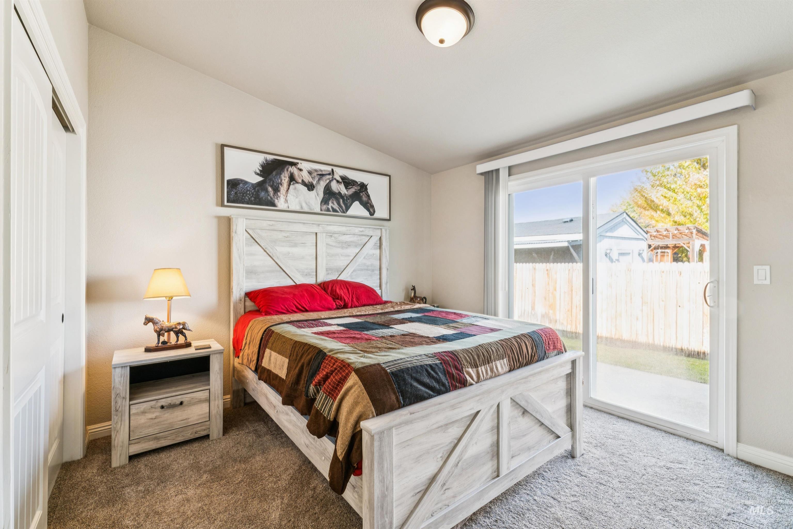 Carpeted bedroom with lofted ceiling, access to outside, and a closet