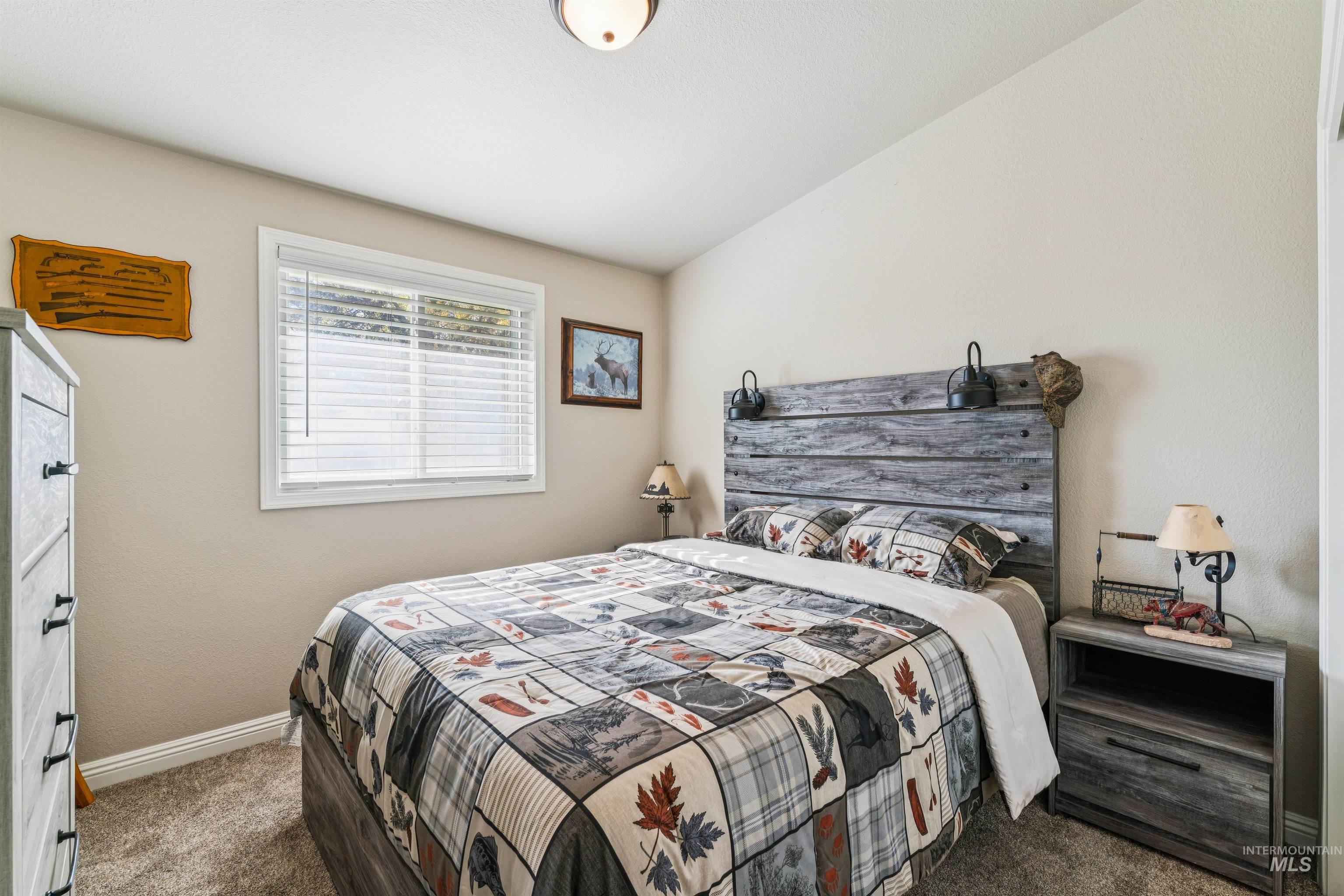 Bedroom with dark carpet and baseboards