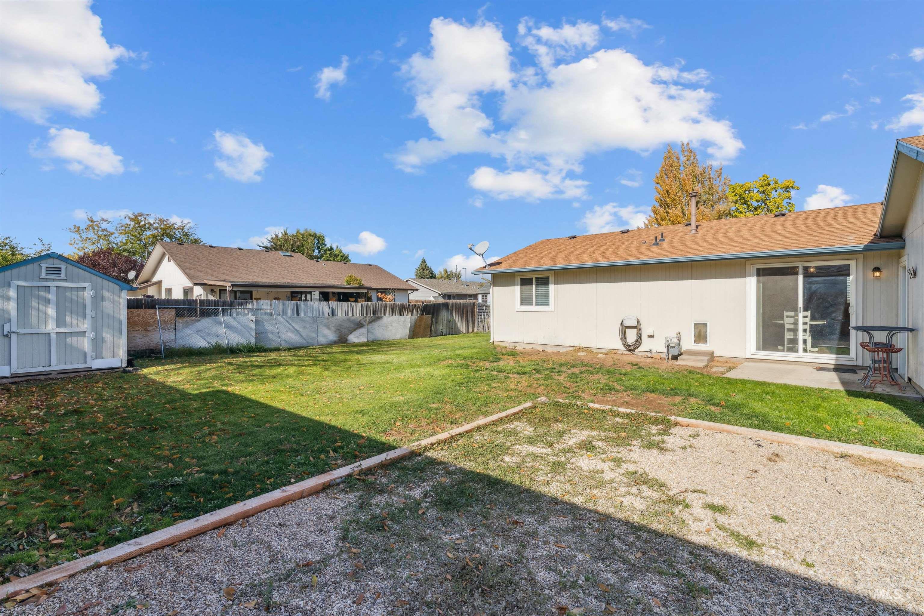 Fenced backyard featuring a shed, a patio, and a residential view