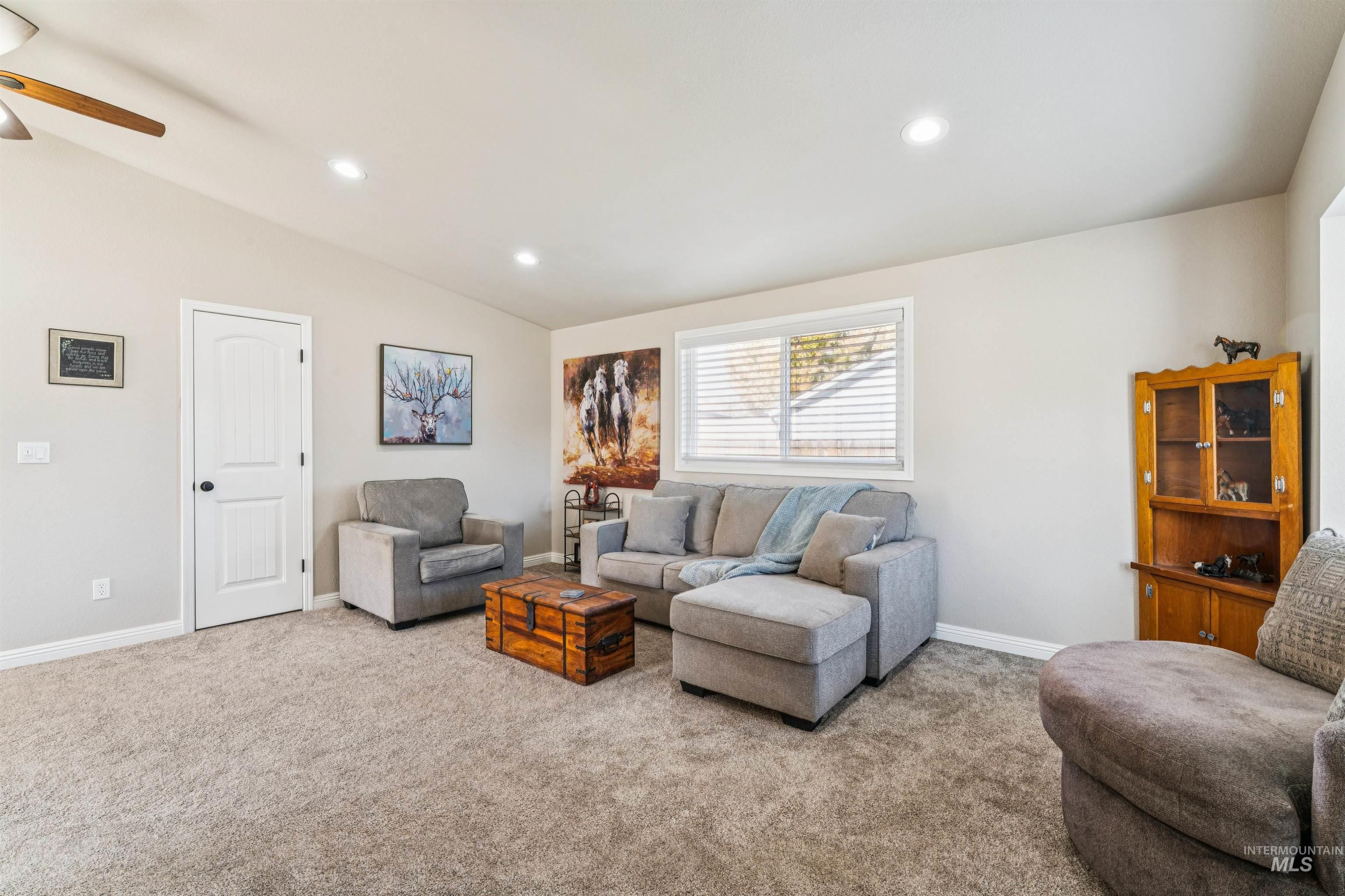 Living room with vaulted ceiling, carpet flooring, recessed lighting, and ceiling fan