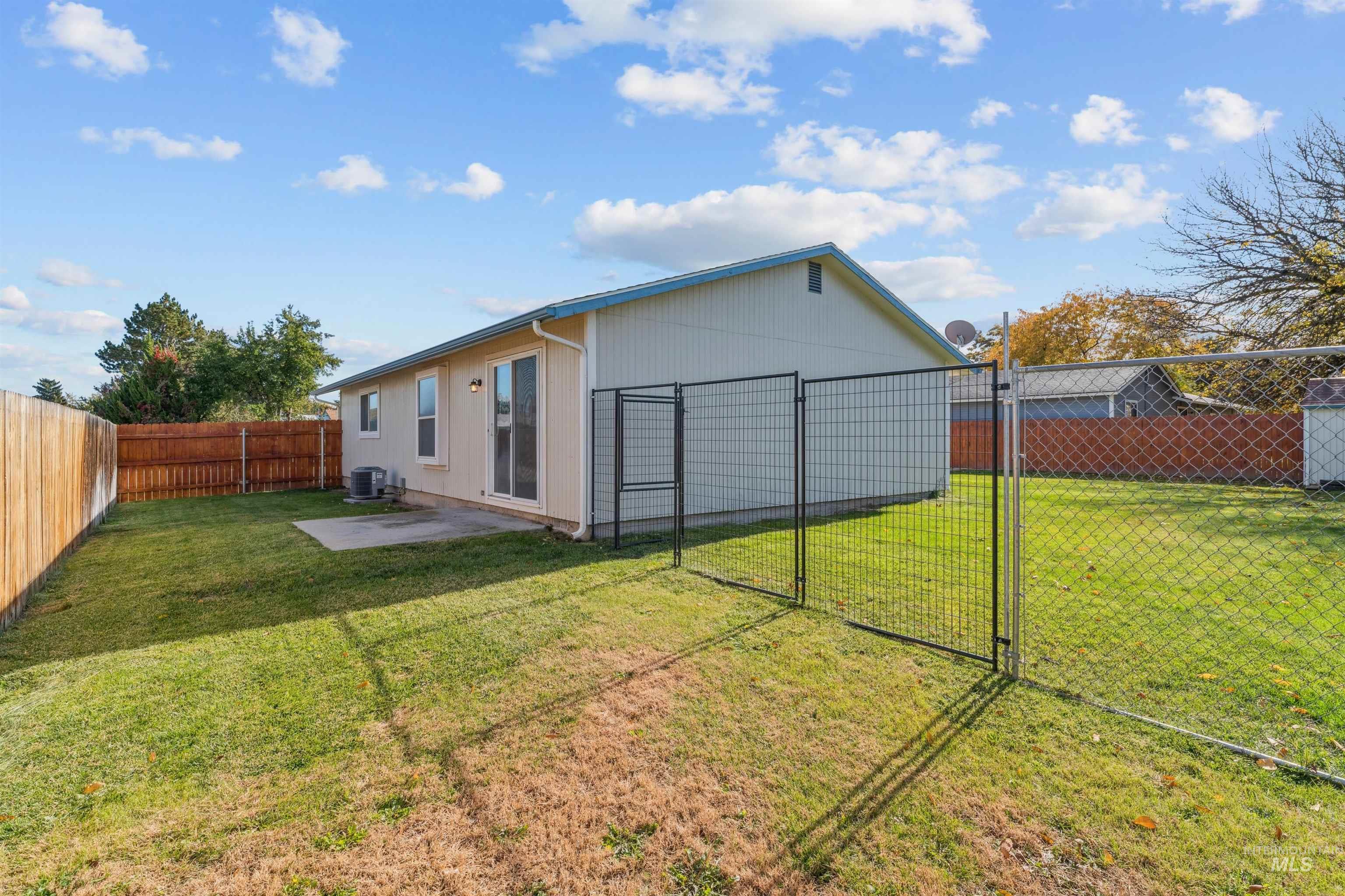 Back of house with a patio area, a fenced backyard, and a gate