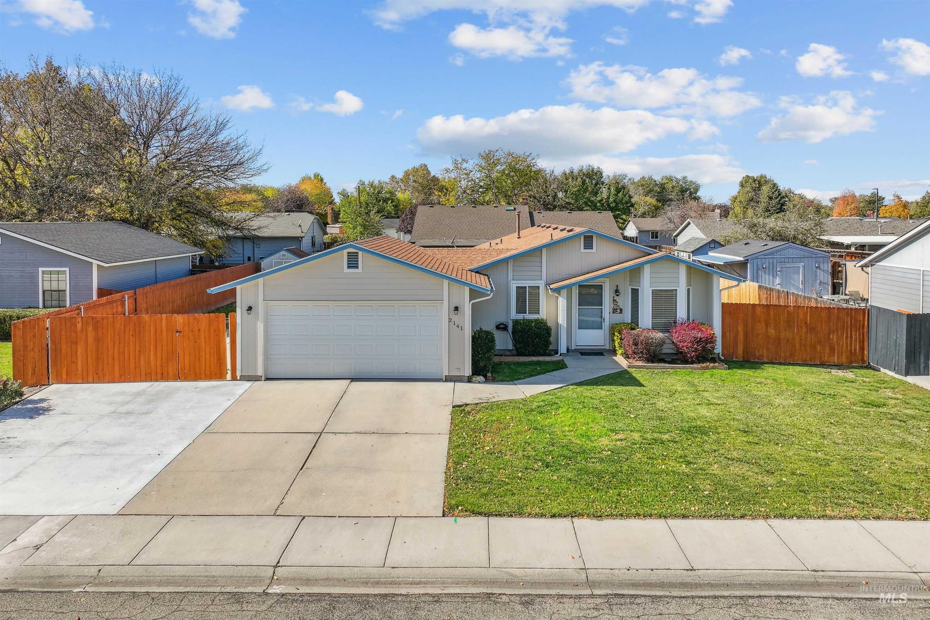 View of front of home with driveway, a residential view, and a garage