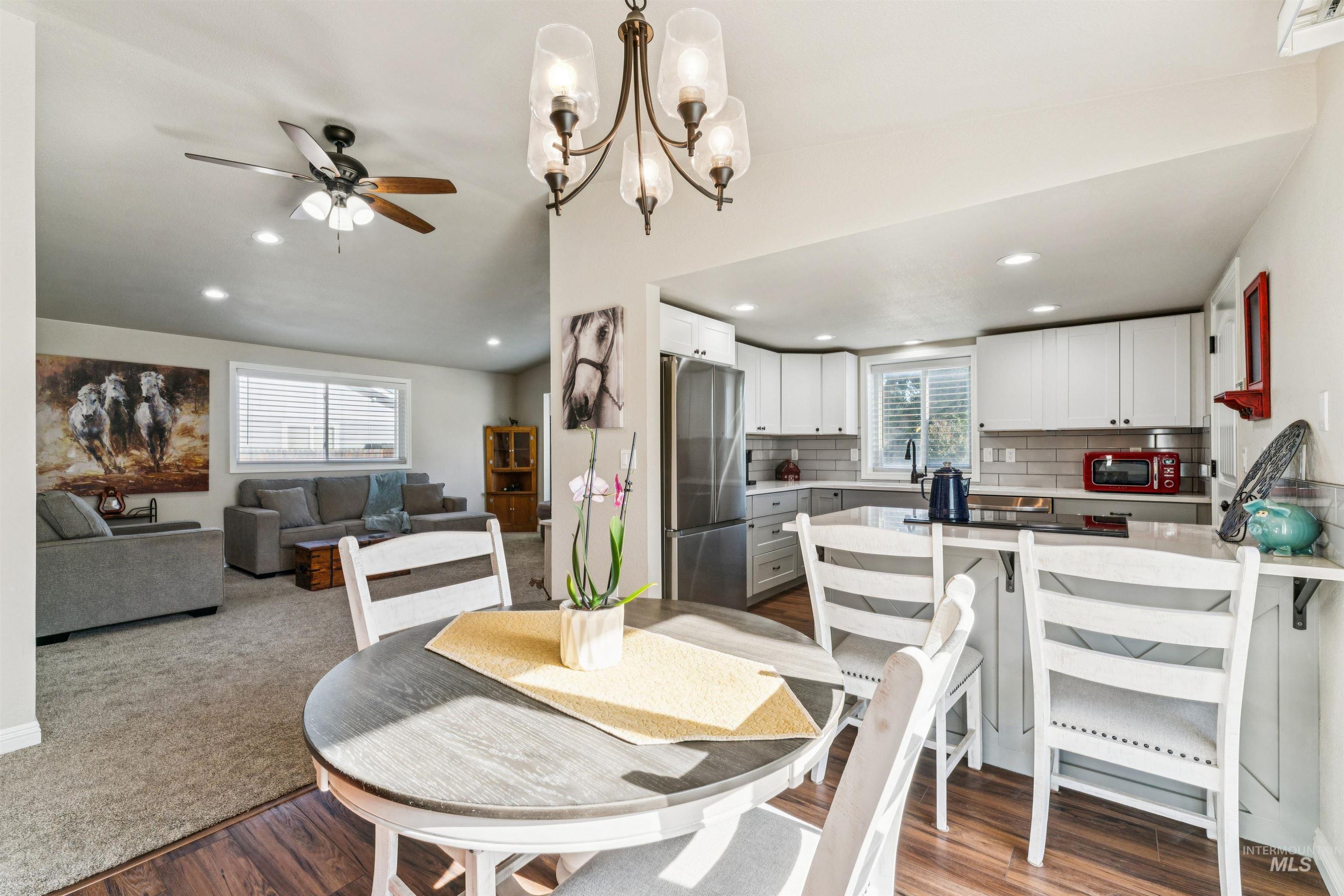 Dining room featuring light wood finished floors, recessed lighting, a chandelier, and a ceiling fan