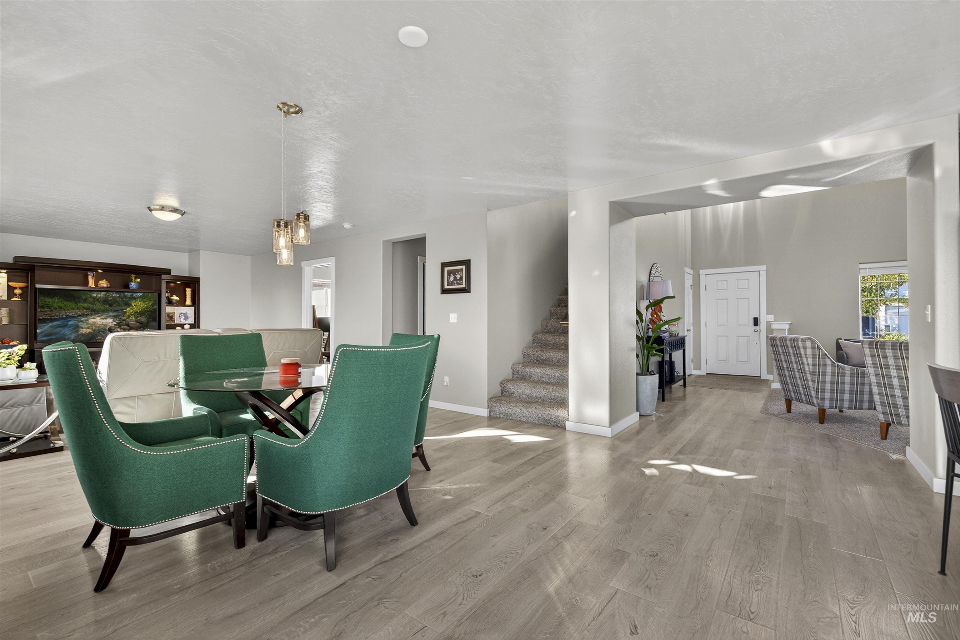 Dining area with wood finished floors and stairway