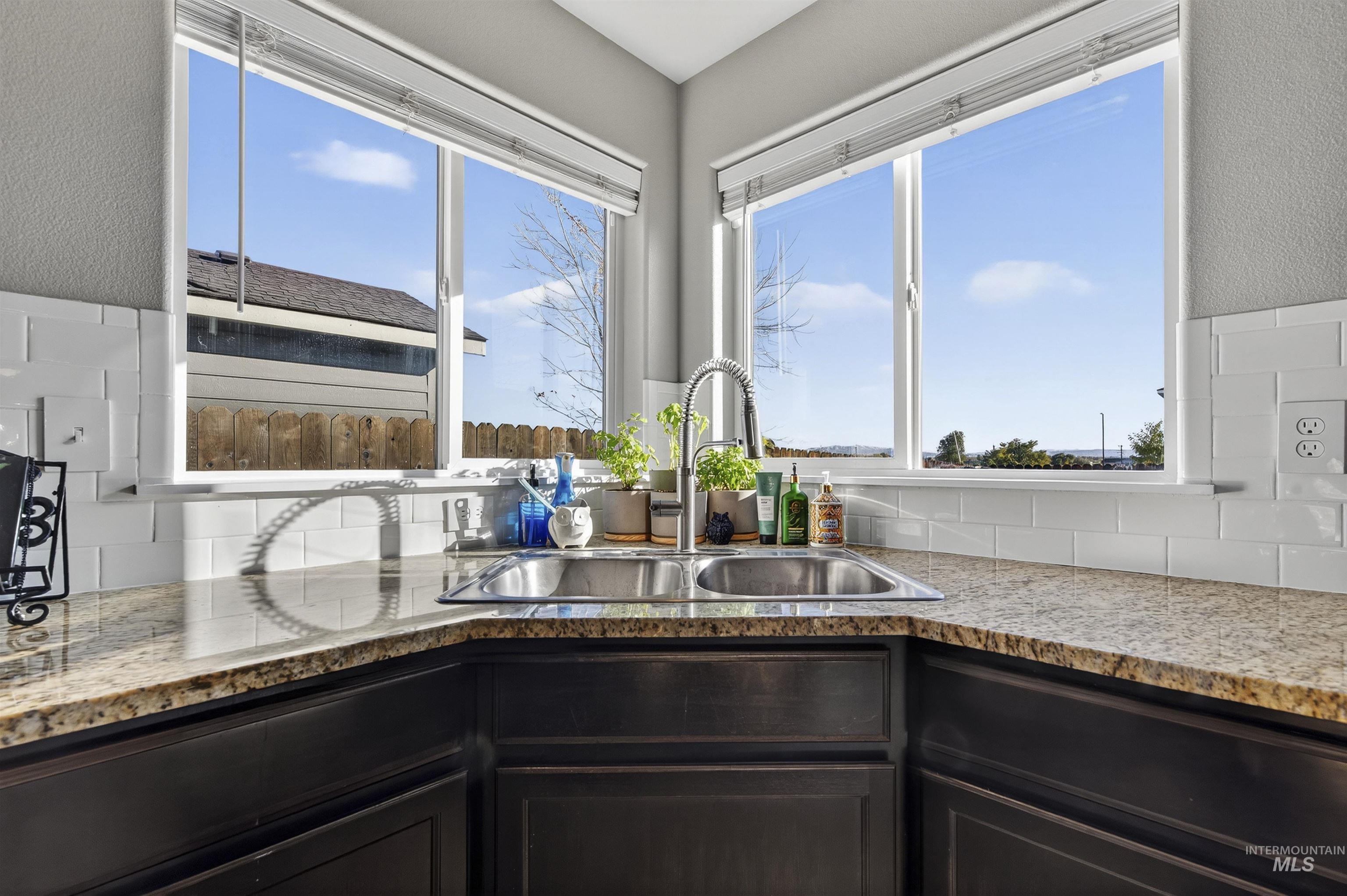 Kitchen with light stone counters and backsplash