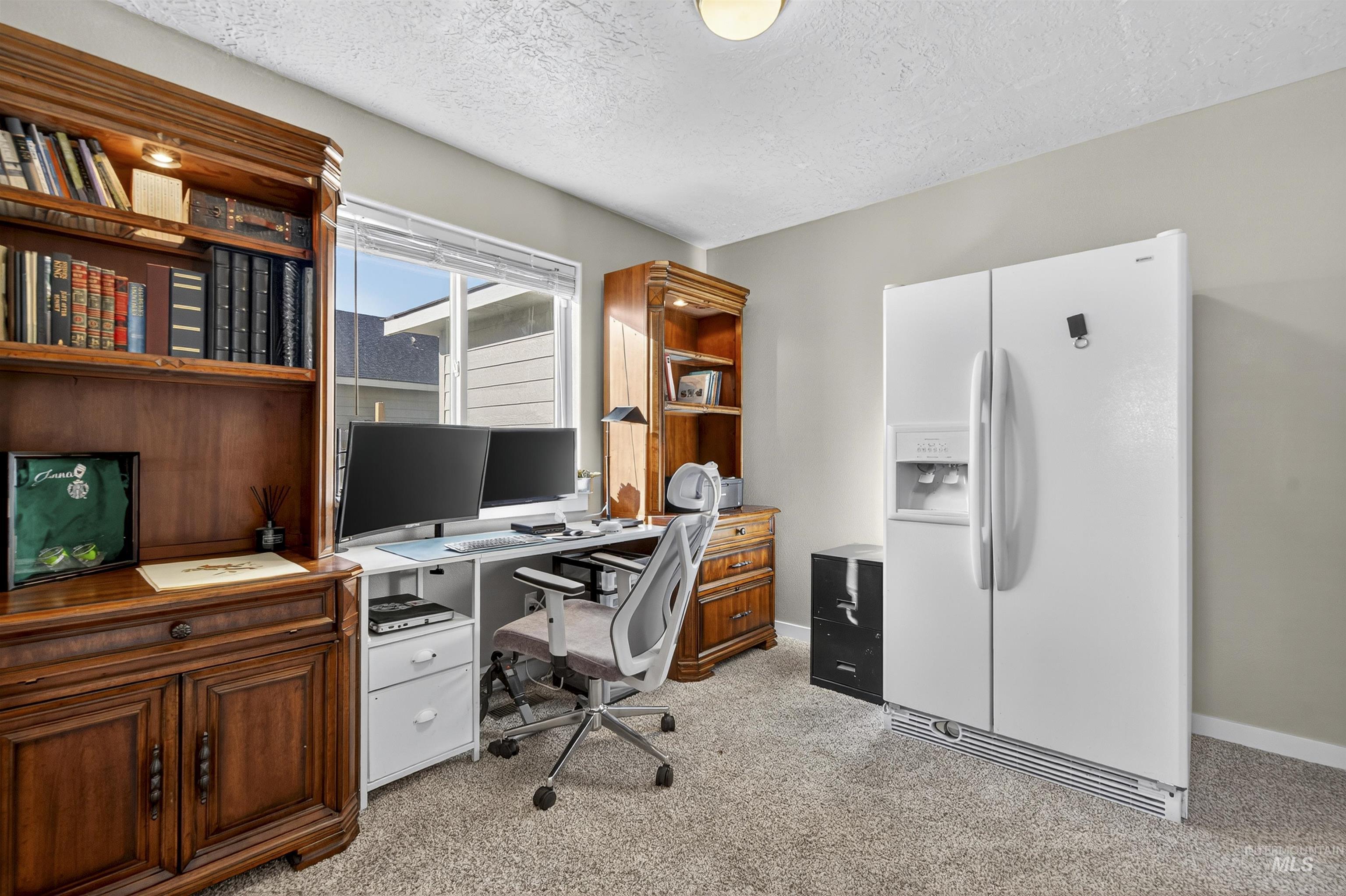 Office featuring a textured ceiling and light colored carpet