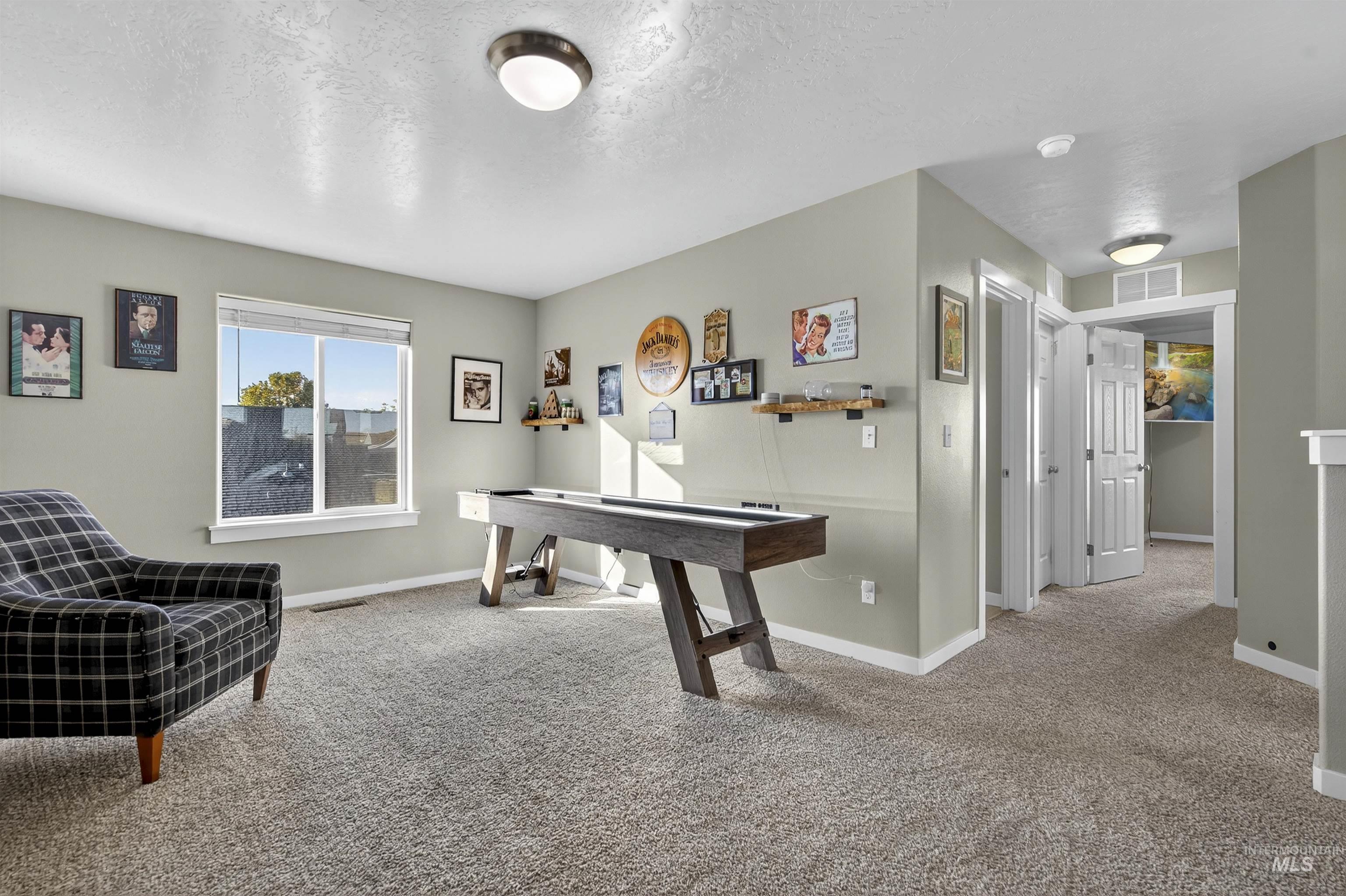 Rec room featuring light carpet and a textured ceiling
