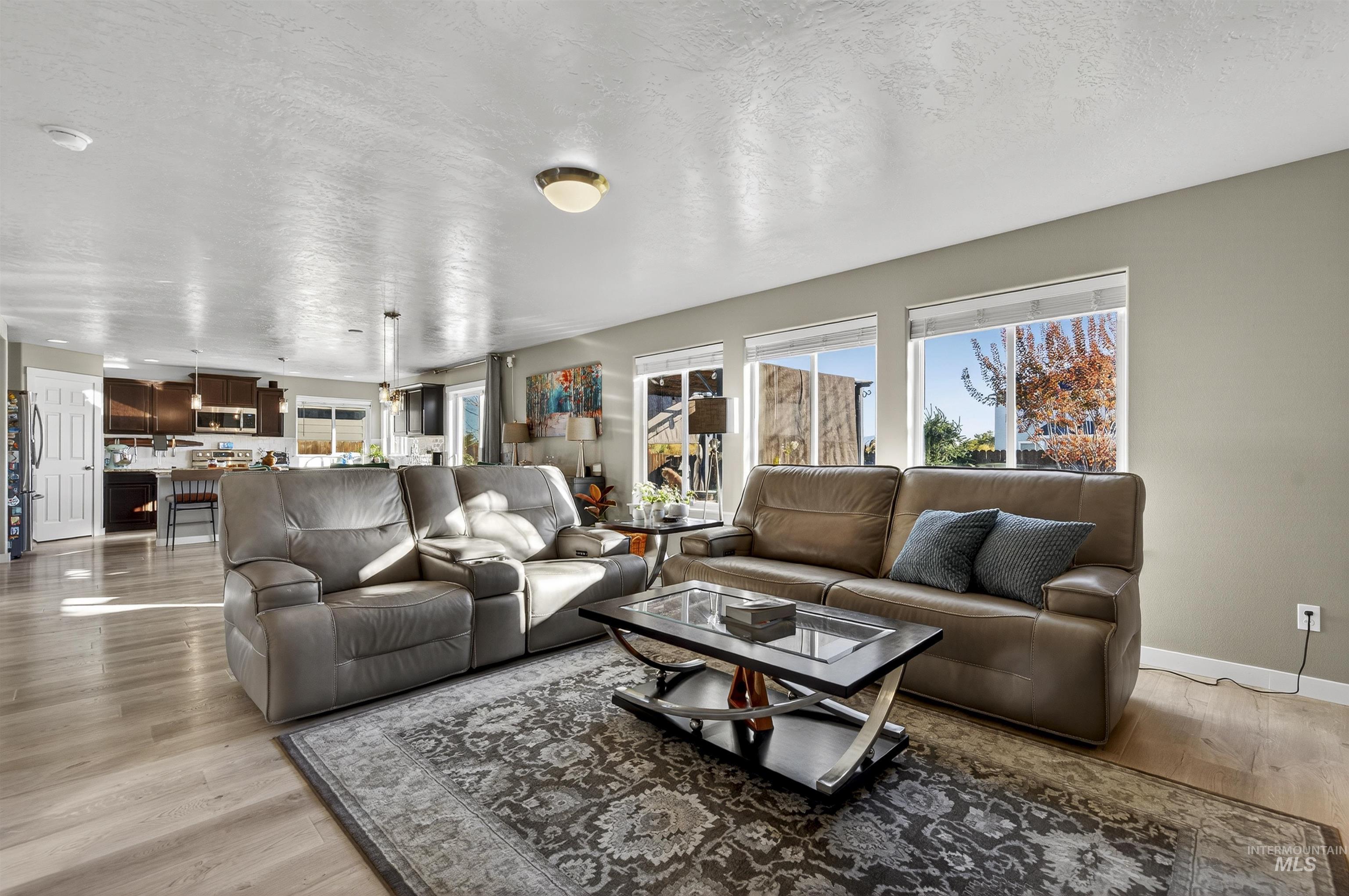 Living room with a textured ceiling and light wood-type flooring