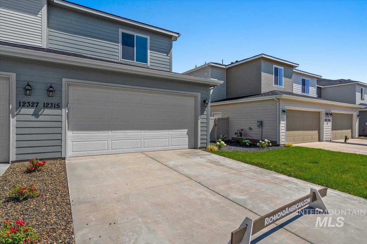 View of front of property featuring a garage and driveway