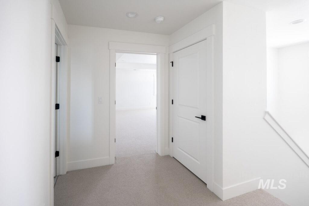 Hall with light carpet and an upstairs landing