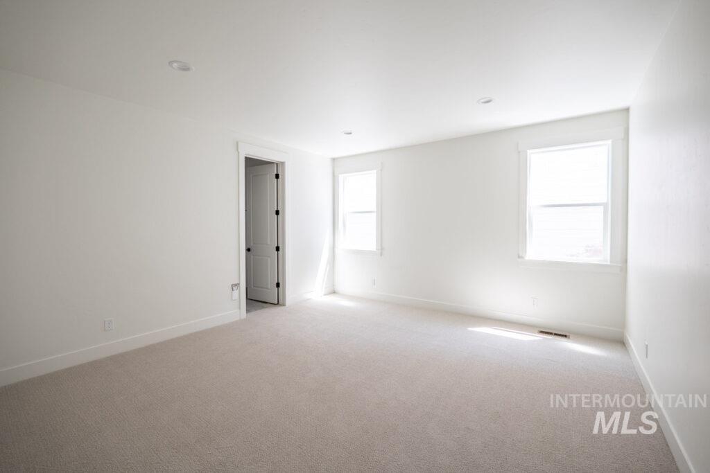 Carpeted empty room with baseboards