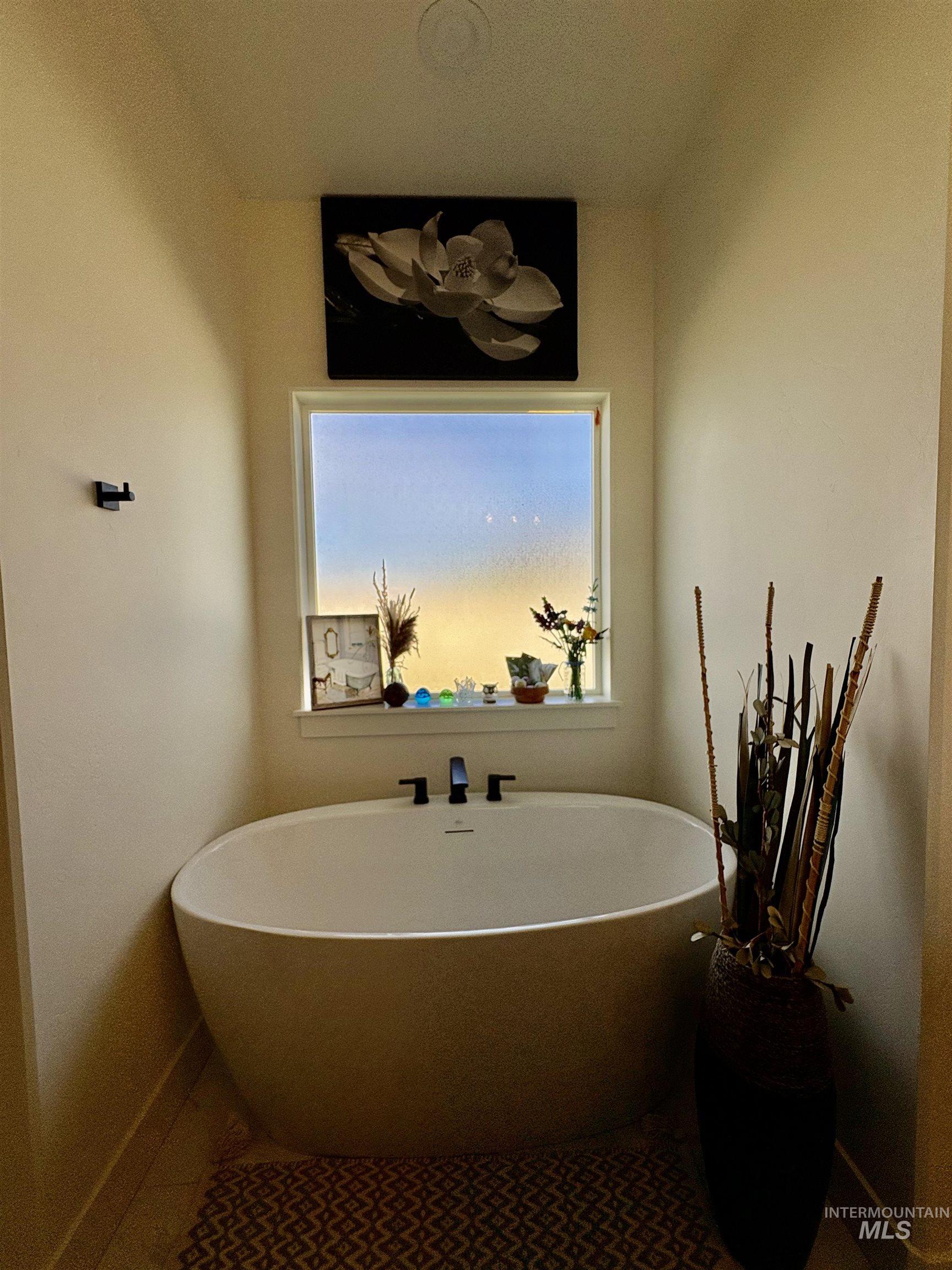 Bathroom with a freestanding tub and tile patterned floors