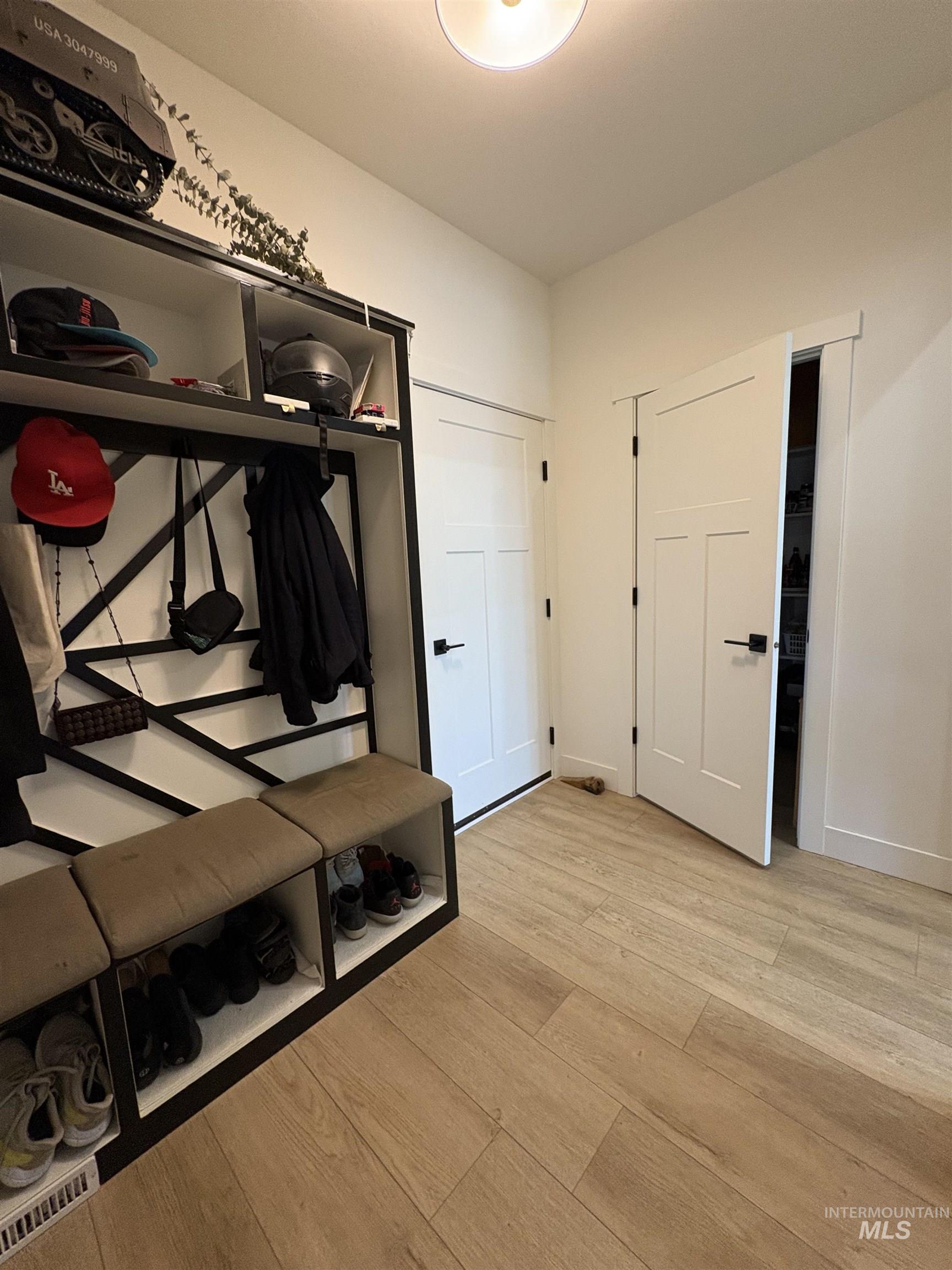 Mudroom with light wood finished floors and baseboards