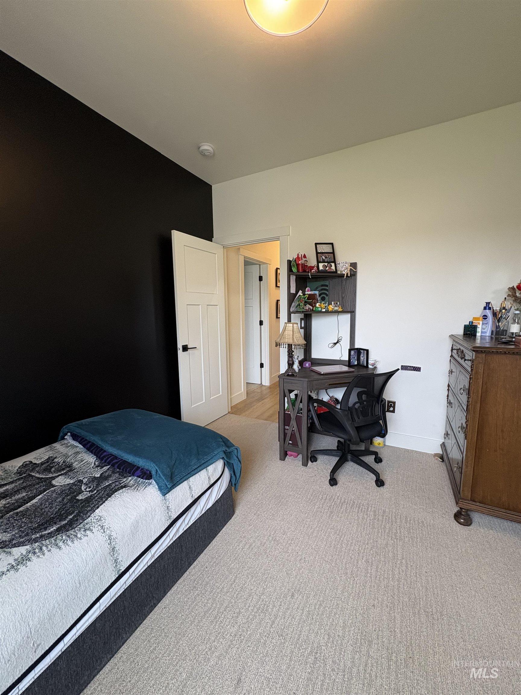 Bedroom with an office area and light colored carpet